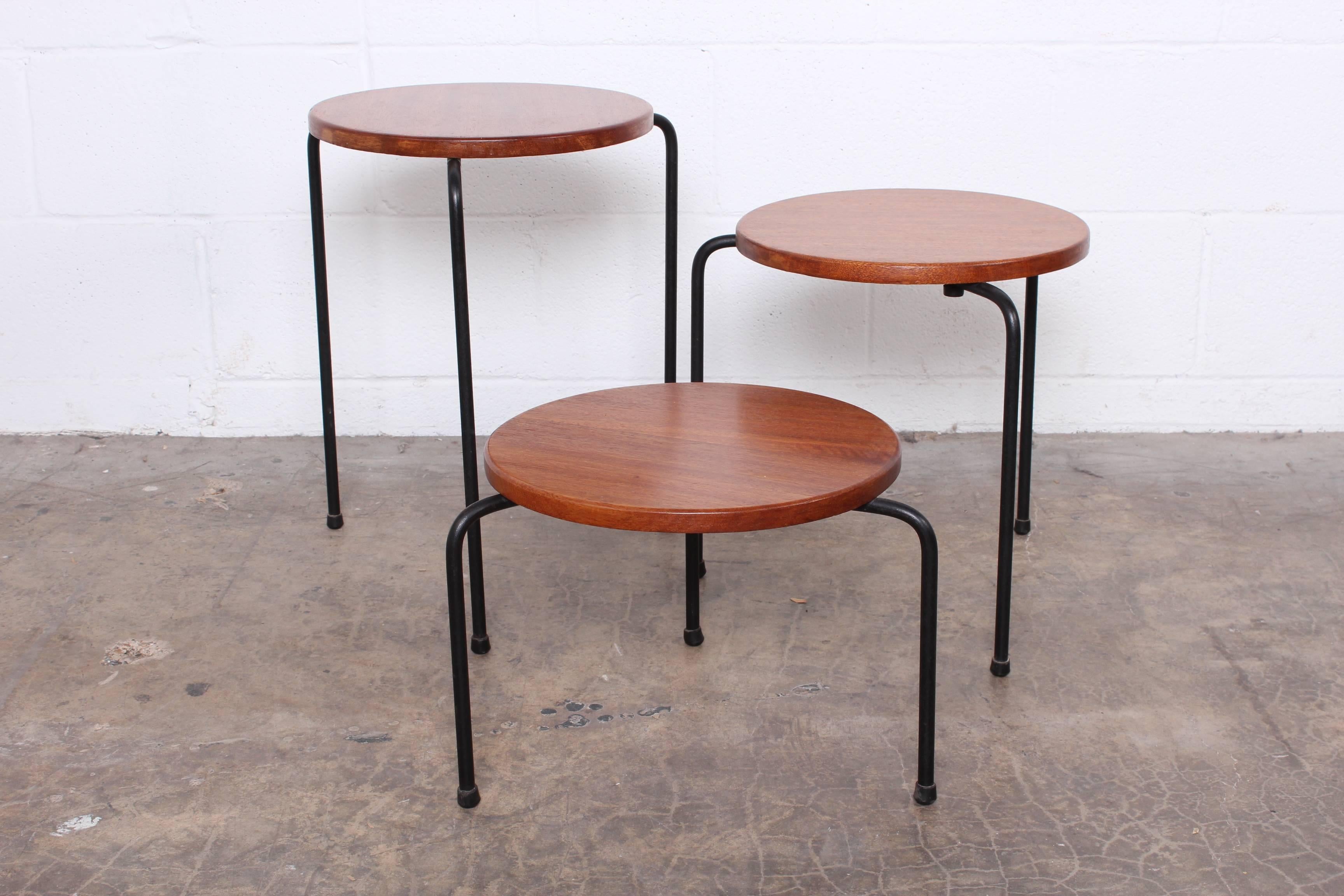 A set of three mahogany and iron nesting tables designed by Luther Conover.