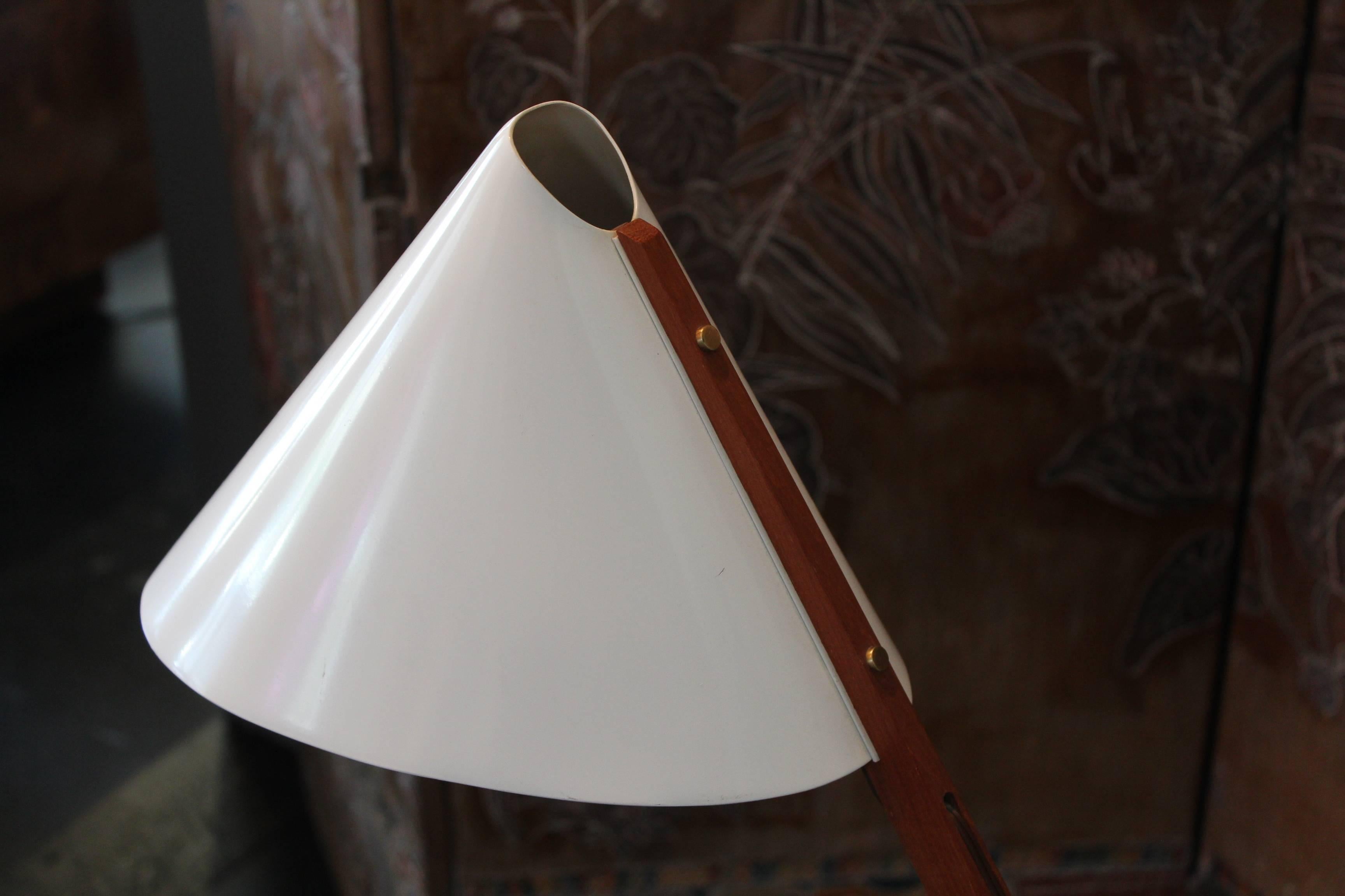 A beautifully detailed desk lamp with enameled shade, teak frame with brass hardware and swiveling weighted base.
