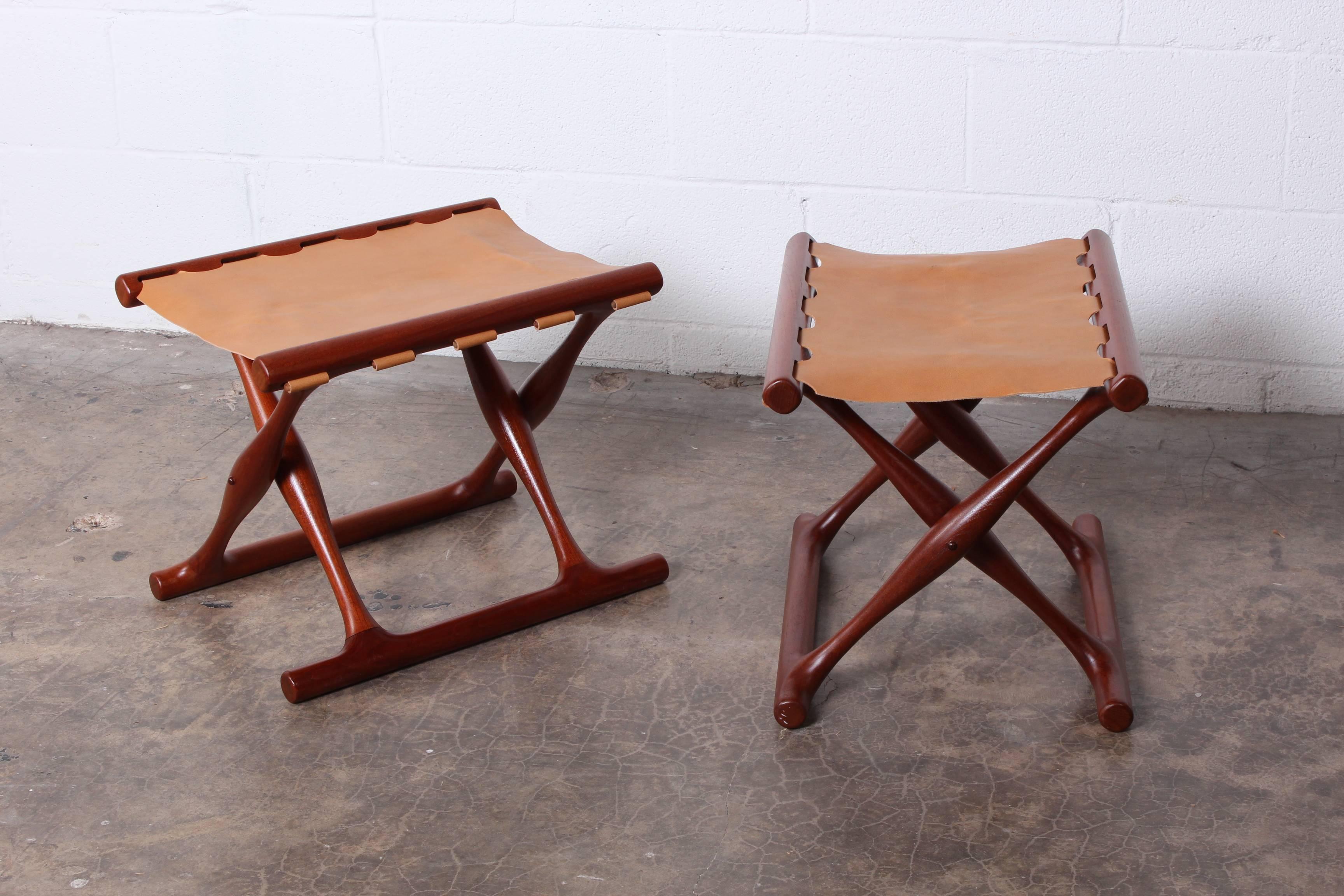 A pair of Danish teak and leather stools designed by Poul Hundevad.
