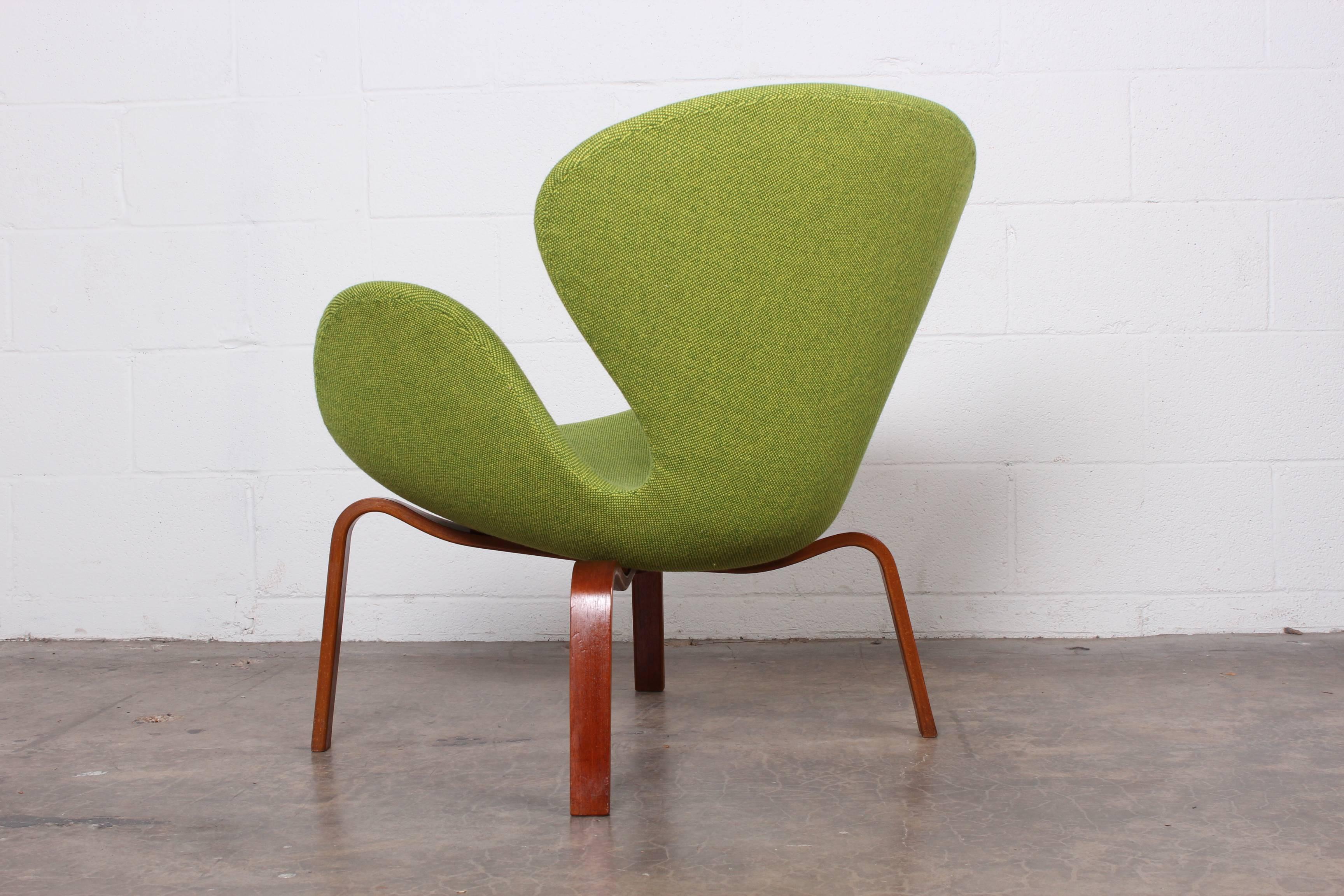 An early swan chair on teak legs. Designed by Arne Jacobsen for Fritz Hansen.