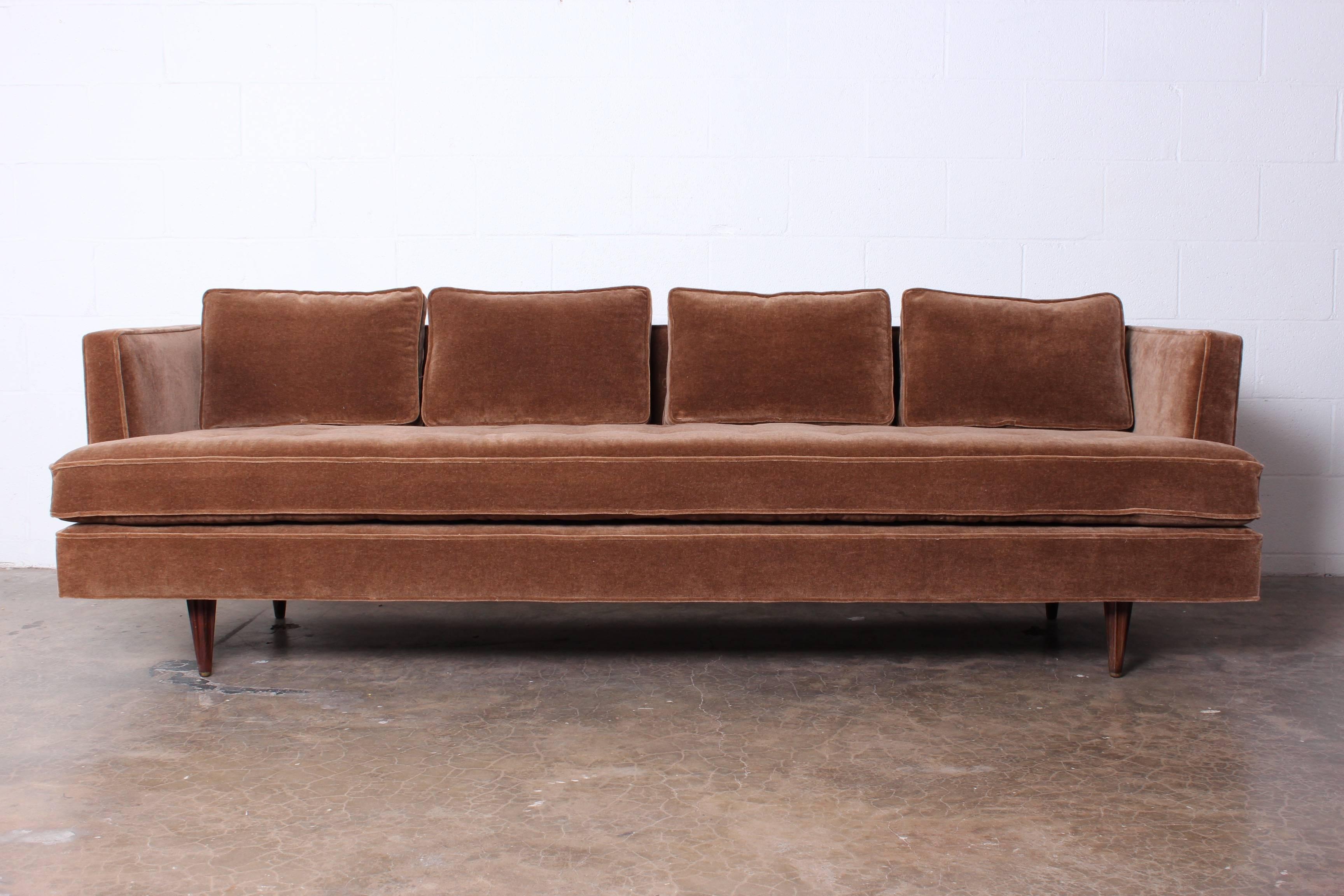 A Classic Dunbar sofa fully restored with mohair fabric and down cushions. This version has rare fluted rosewood legs with brass tips. Designed by Edward Wormley.