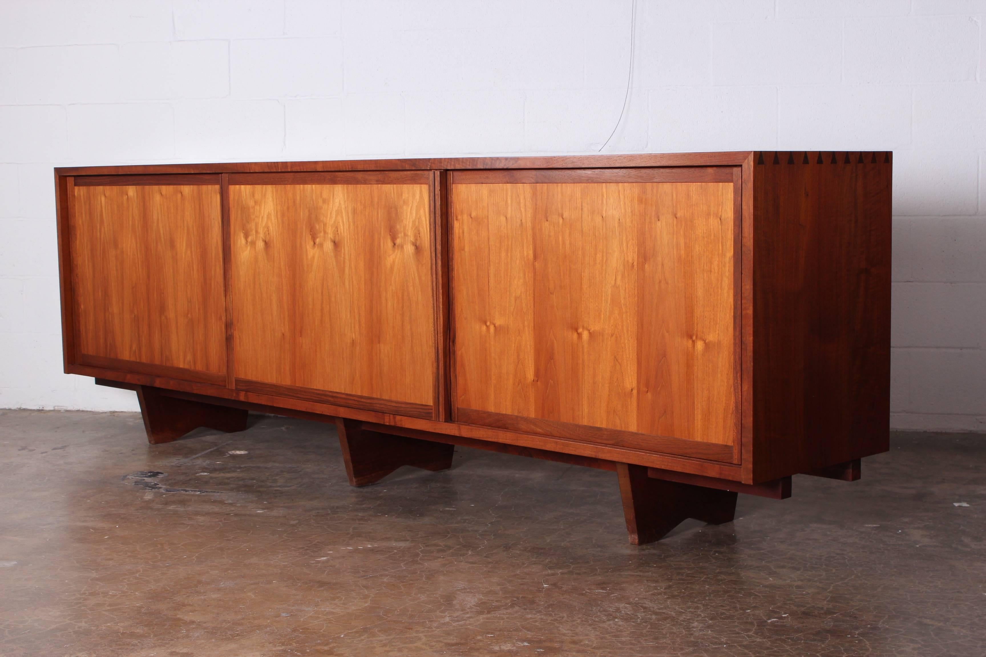 A large sliding three door walnut credenza by George Nakashima. Signed and dated 1978.