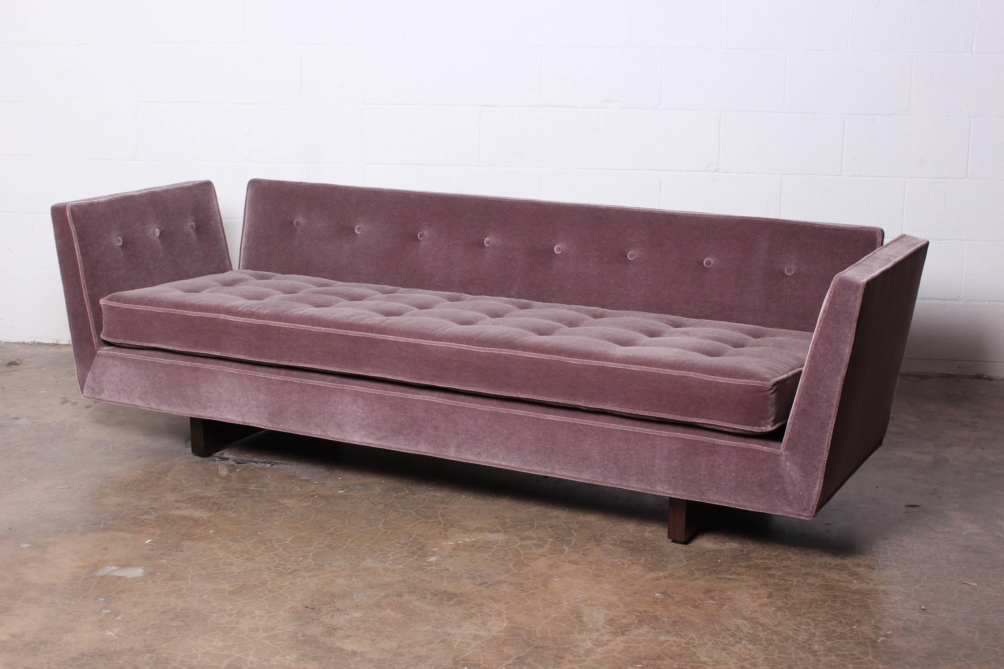 A beautifully restored split arm sofa with walnut base. Designed by Edward Wormley for Dunbar. Reupholstered in a lavender colored Mohair with down back cushions.