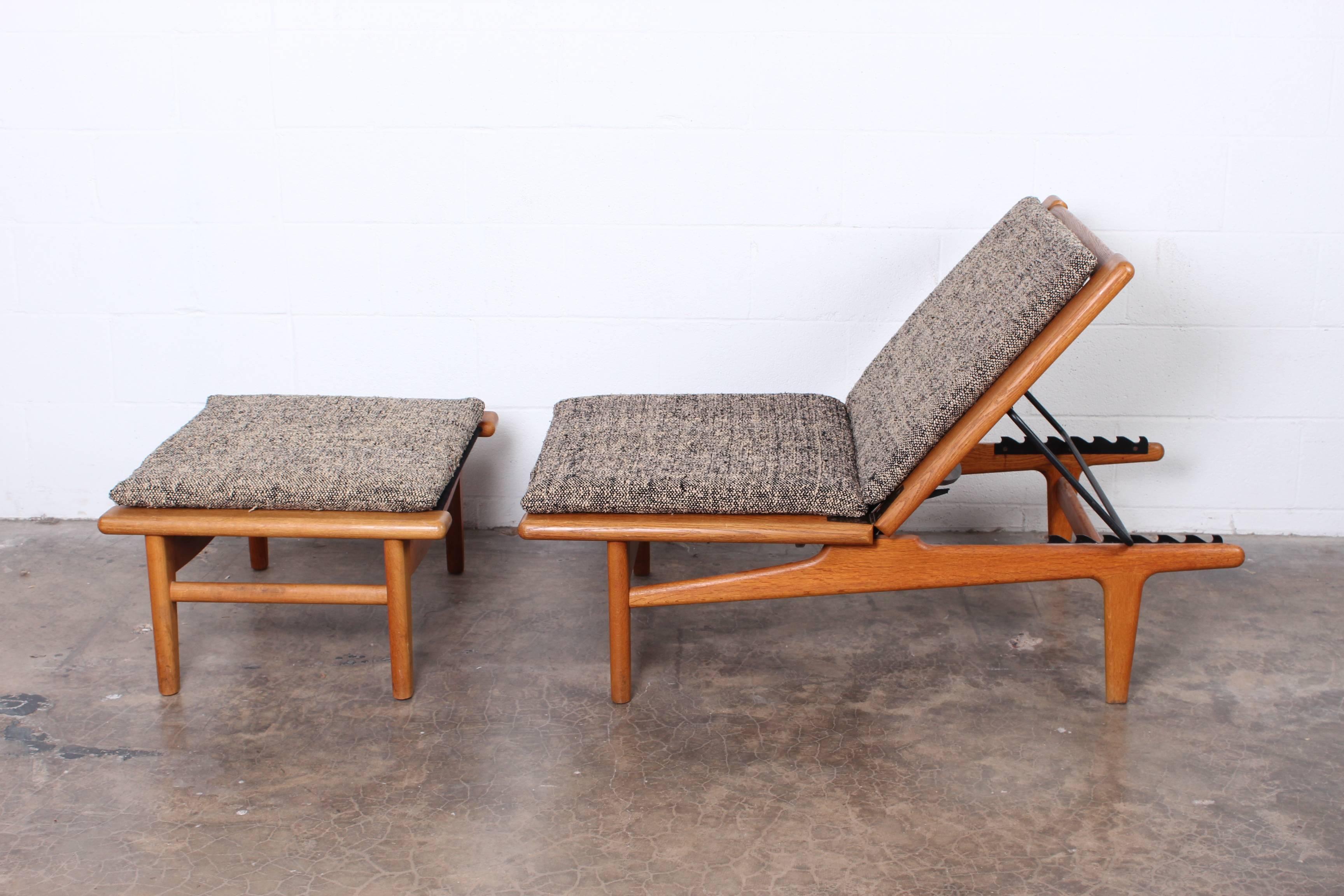 A matching pair of oak chaise longue or benches with ottomans designed by Hans Wegner. 
Ottoman measures 30 x 23.5 x 15.