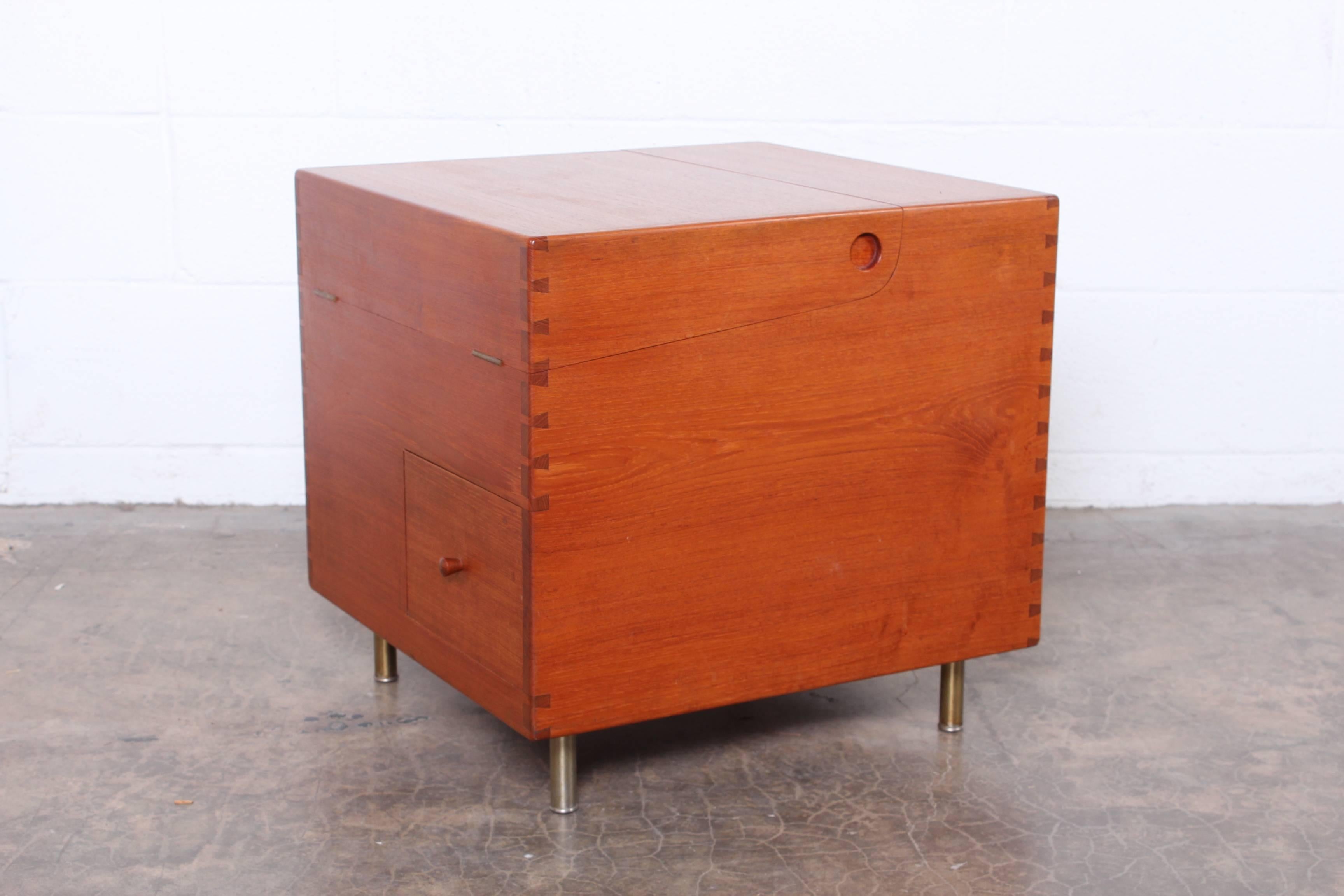 A solid teak cube bar cabinet model 8034 designed by Hans Wegner for Andreas Tuck, with dovetail joinery, on satin chromed cylinder legs.