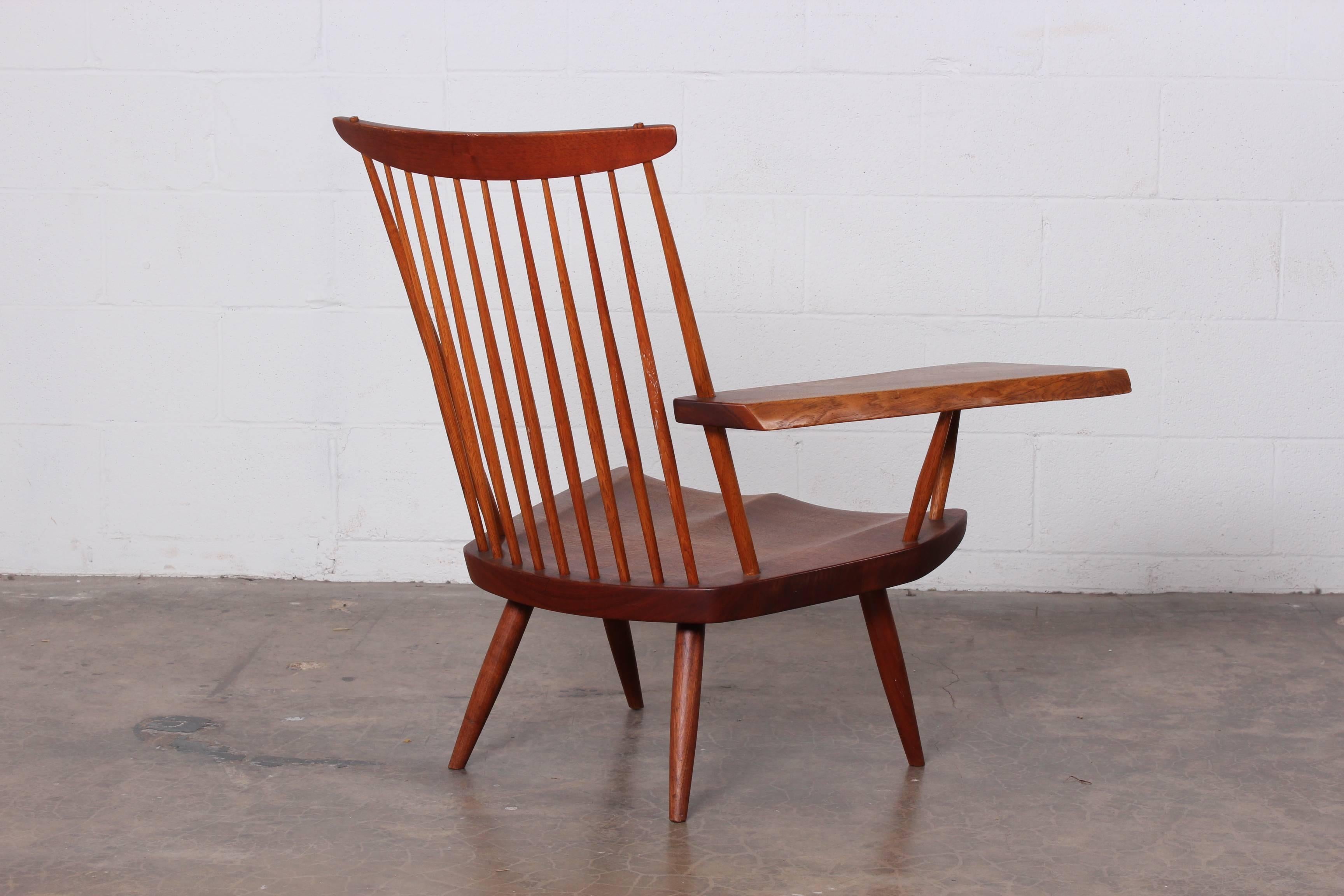 A walnut and hickory single arm lounge chair by George Nakashima, 1968. Sold with copies of original order card.