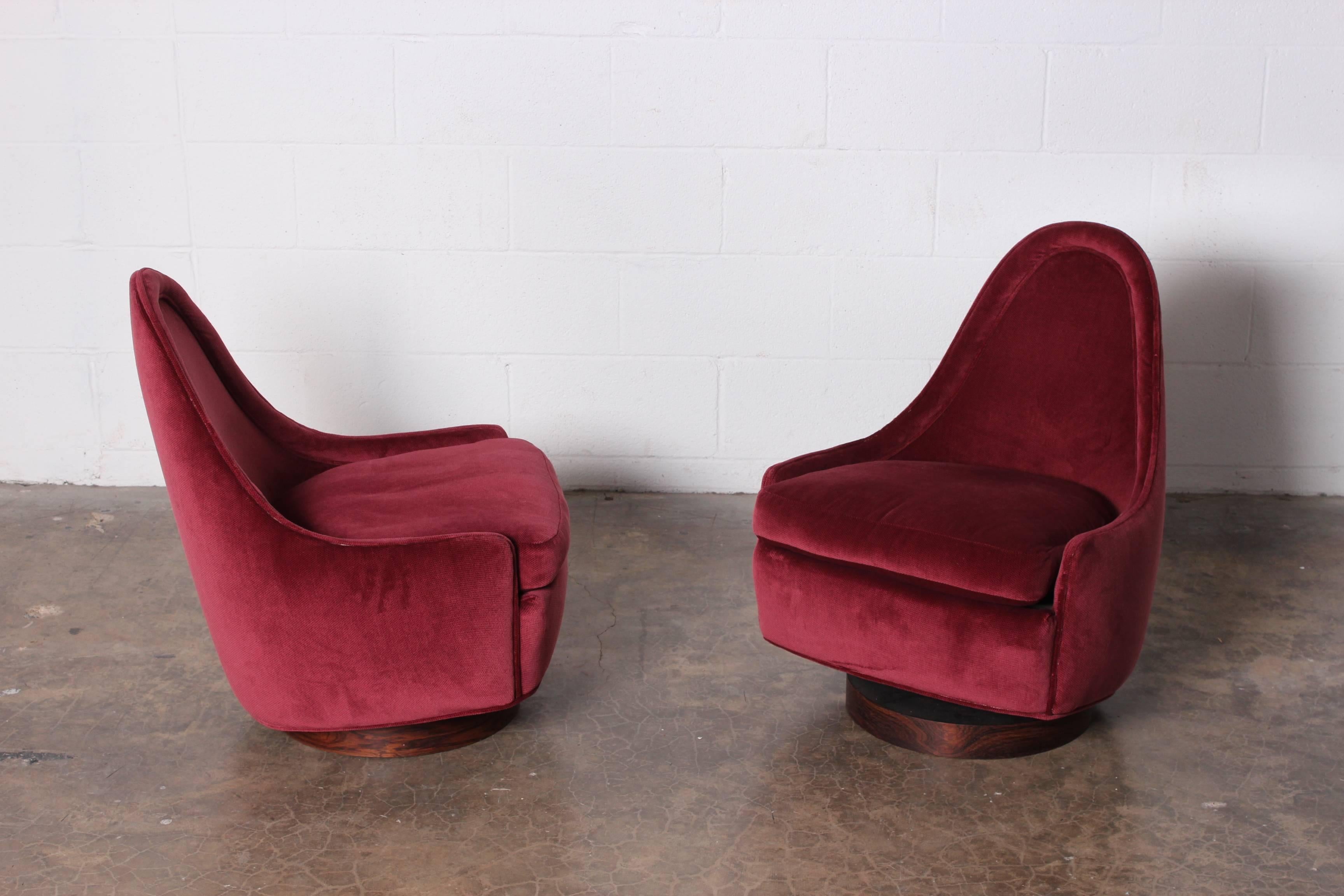 A small-scale pair of rocking swivel chairs on rosewood bases. Designed by Milo Baughman for Thayer Coggin.