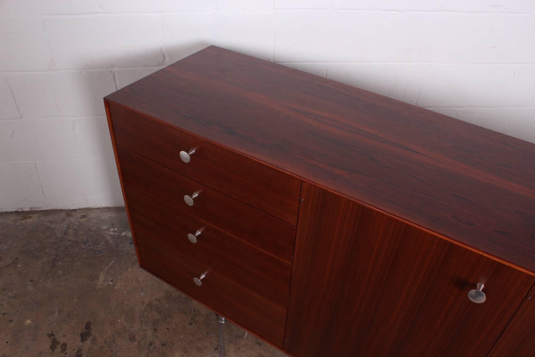 A thin edge cabinet designed by George Nelson for Herman Miller with rosewood case and walnut doors.