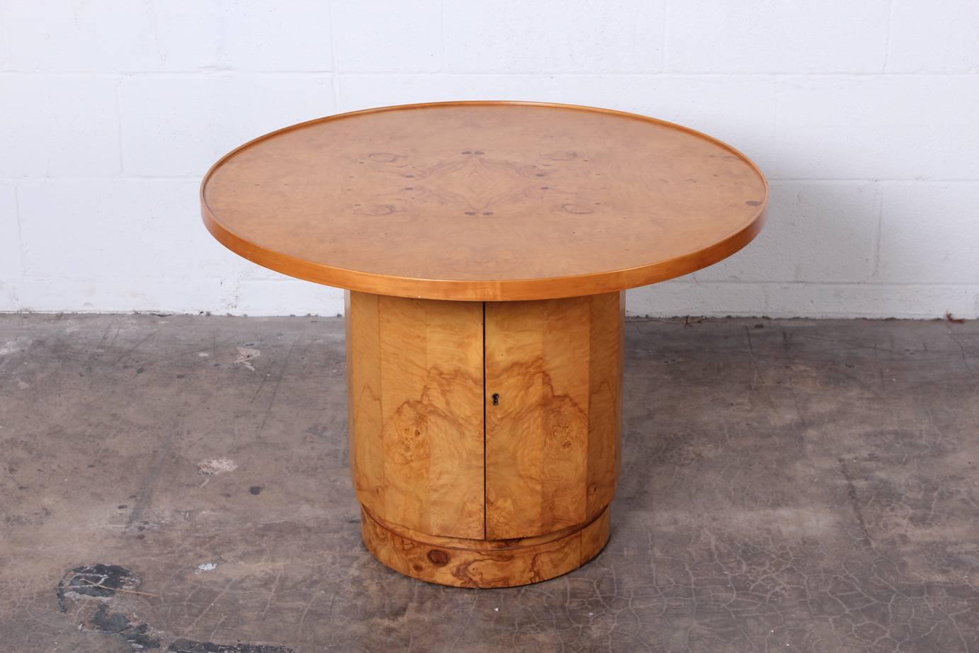 A large olive burl table with concealed dry bar storage. Designed by Edward Wormley for Dunbar.