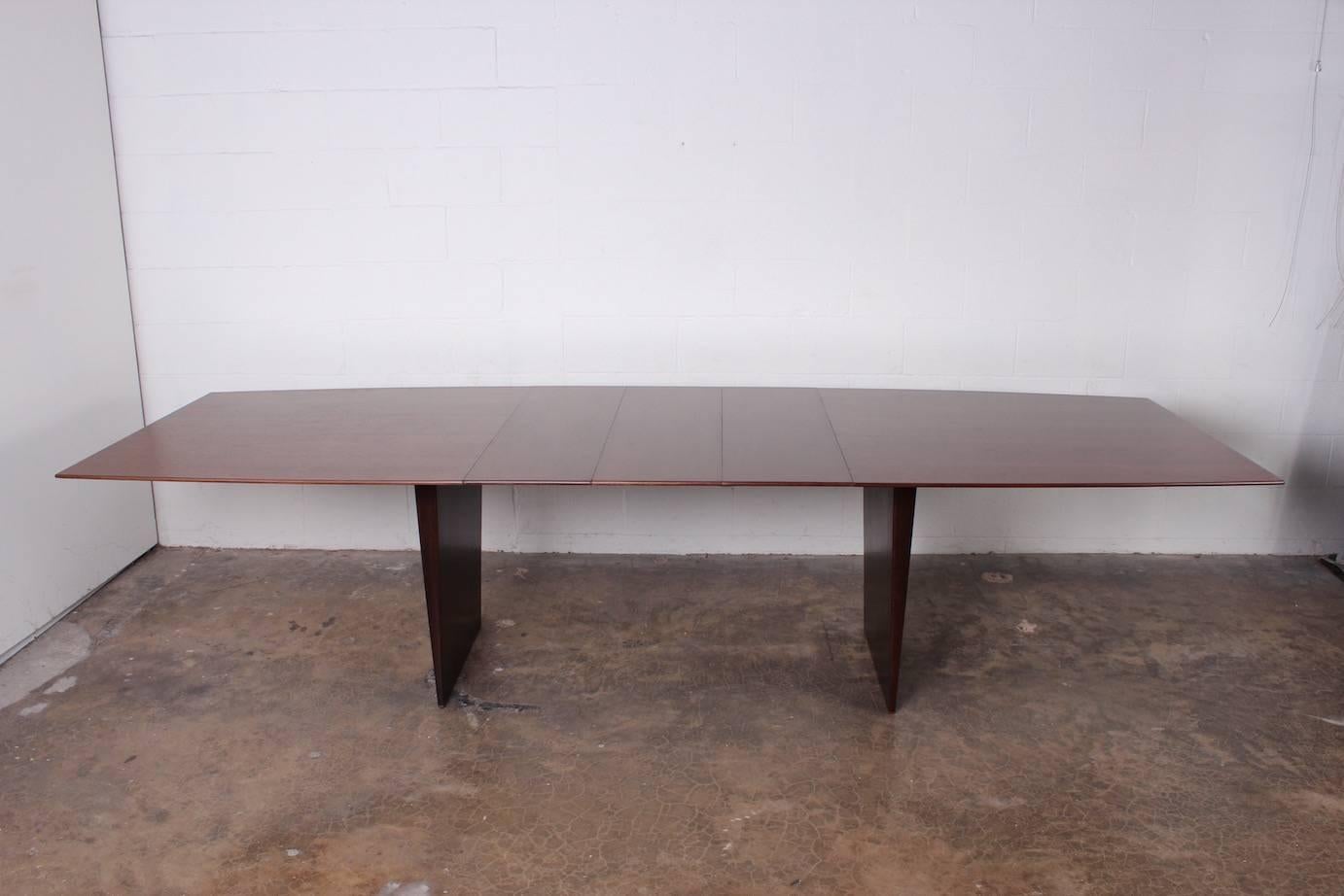 A large two-toned walnut dining table designed by Edward Wormley for Dunbar. This is the larger version of this table which has three 12