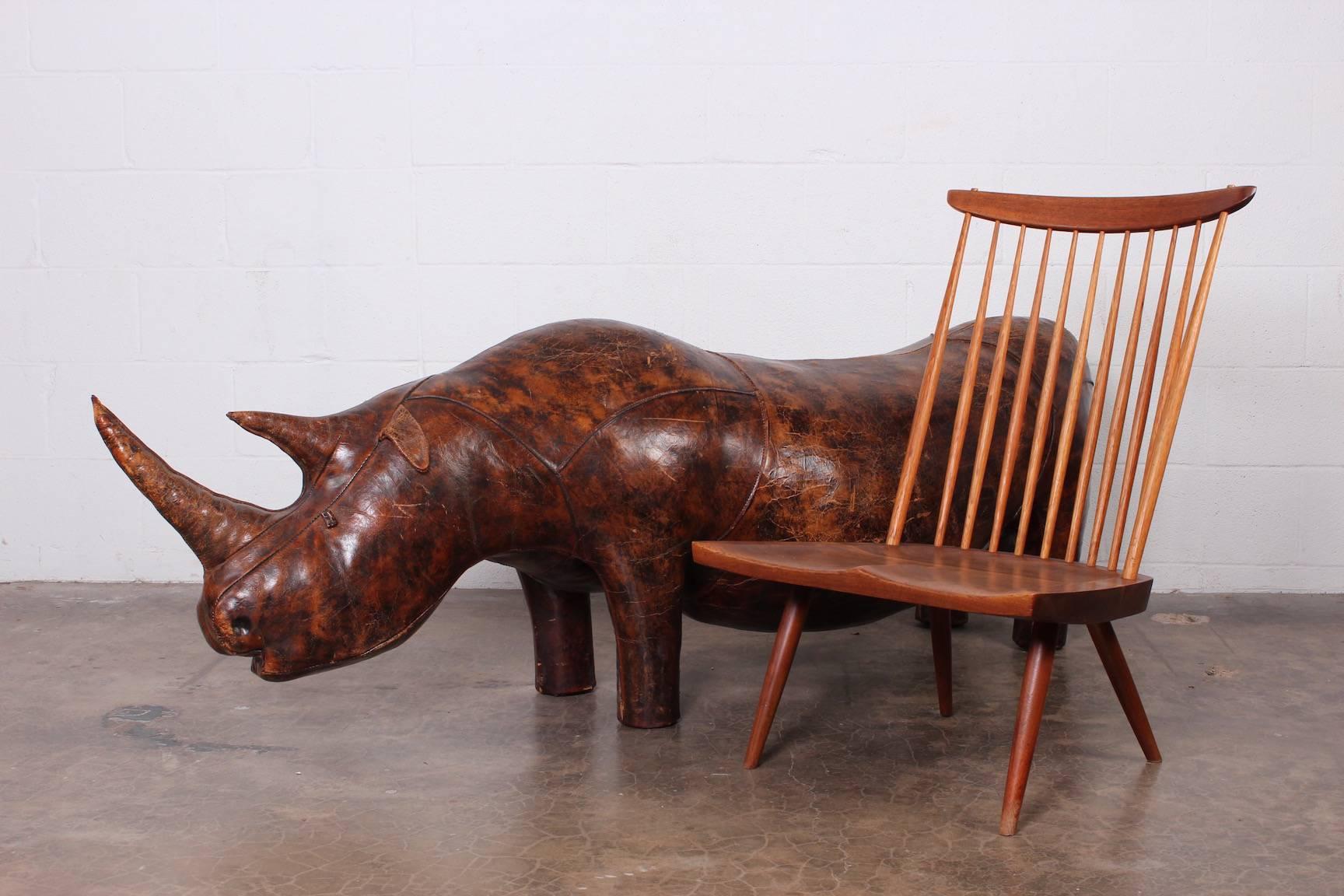 A large patinated leather bench in the form of a rhinoceros. Designed by Dimitri Omersa for Abercrombie & Fitch. Structurally sound and fully functional as a bench.