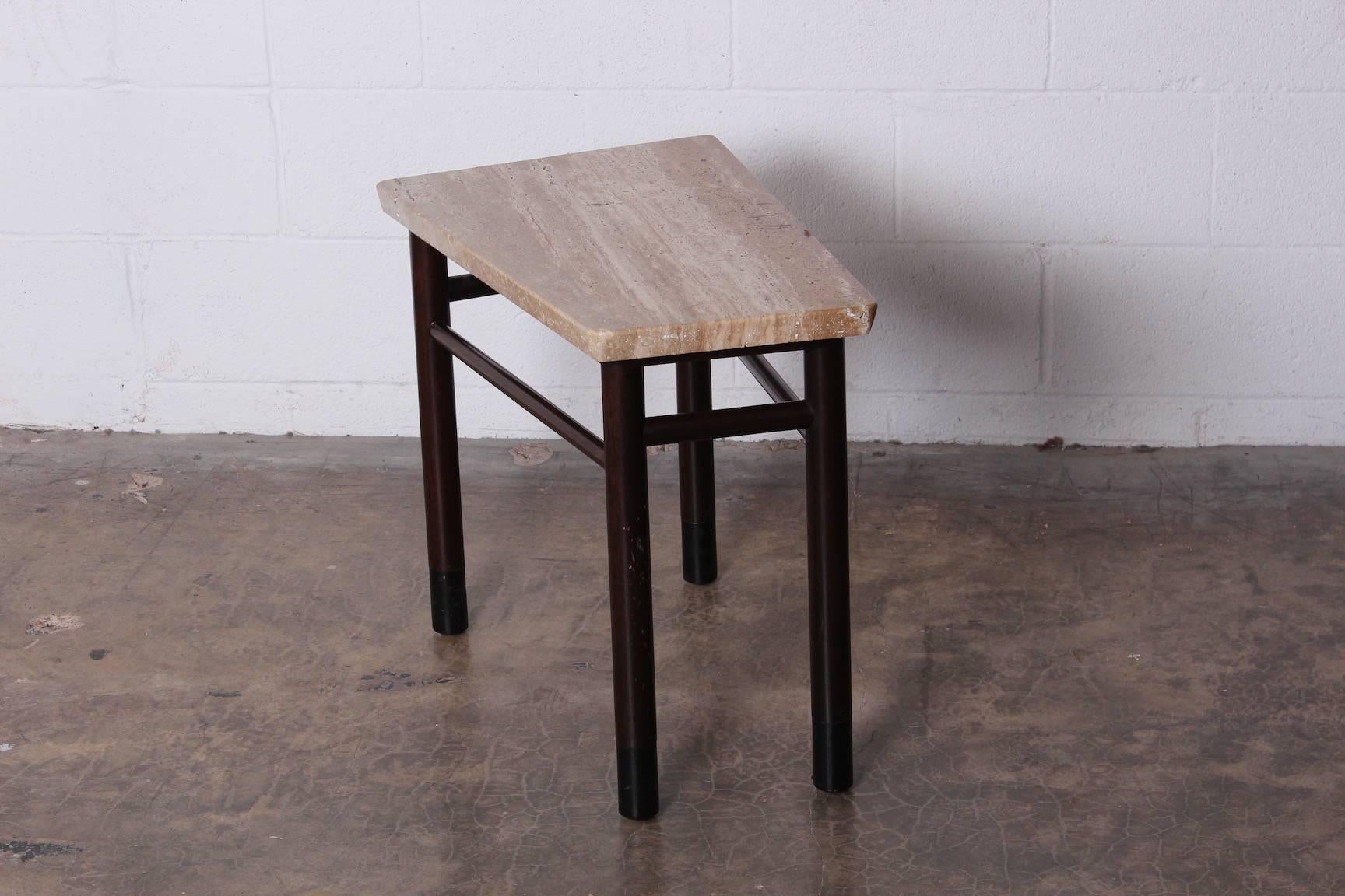 A wedge shaped table with leather wrapped legs and travertine top. Designed by Edward Wormley for Dunbar.