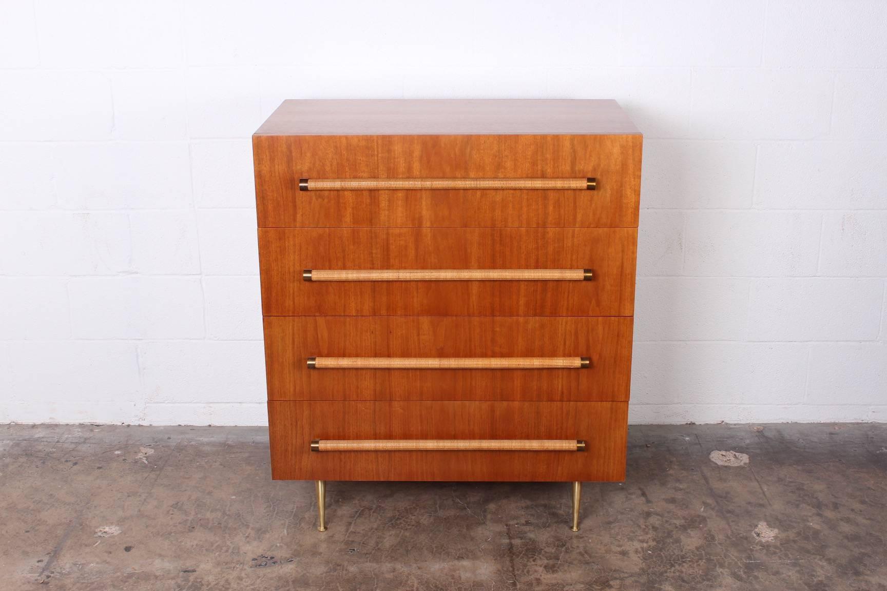 A bleached walnut chest of drawers with cane wrapped handles and brass legs. Designed by T.H. Robsjohn-Gibbings for Widdicomb.