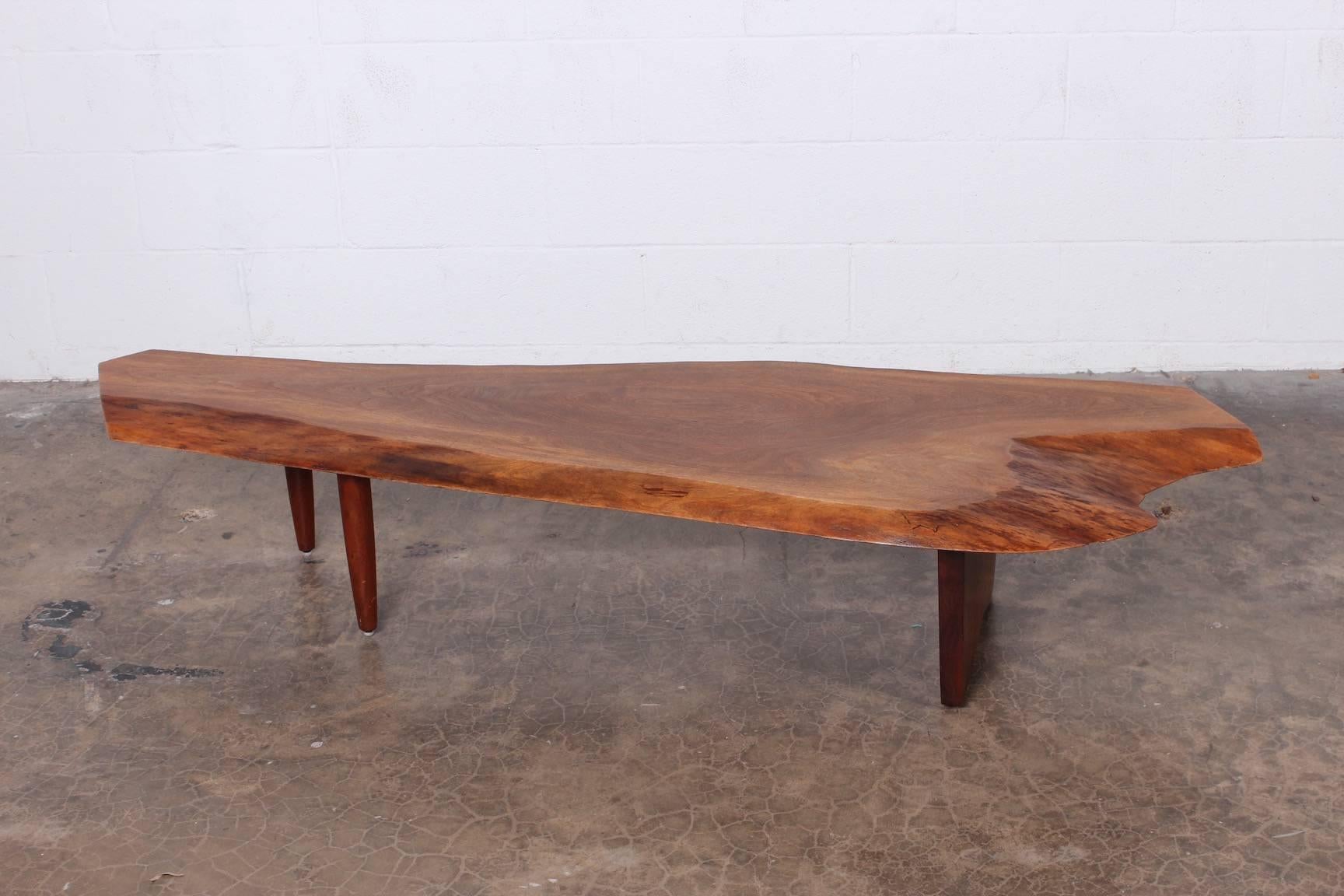 A walnut coffee table/bench by George Nakashima, 1980. Sold with copy of original receipt.