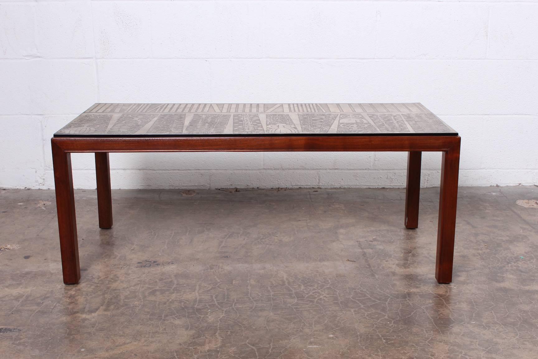 A mahogany coffee table with etched metal top signed by artist and marked 