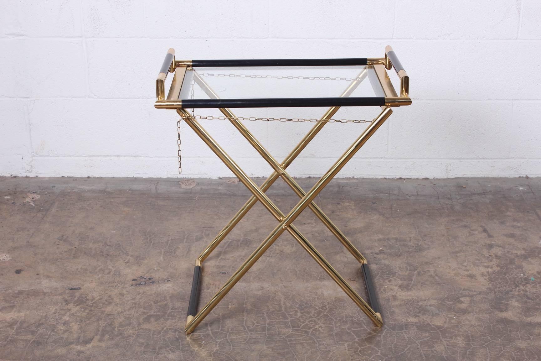 A brass folding tray table marked 