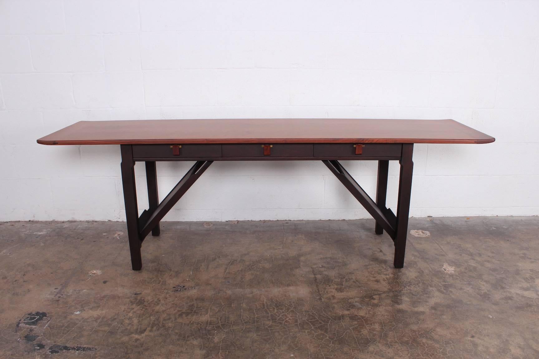 Ein Konsolentisch aus Mahagoni und Nussbaum mit Palisanderholzgriffen. Der Tisch verfügt über Buchhalter auf beiden Seiten und drei Schubladen. Entworfen von Edward Wormley für Dunbar.