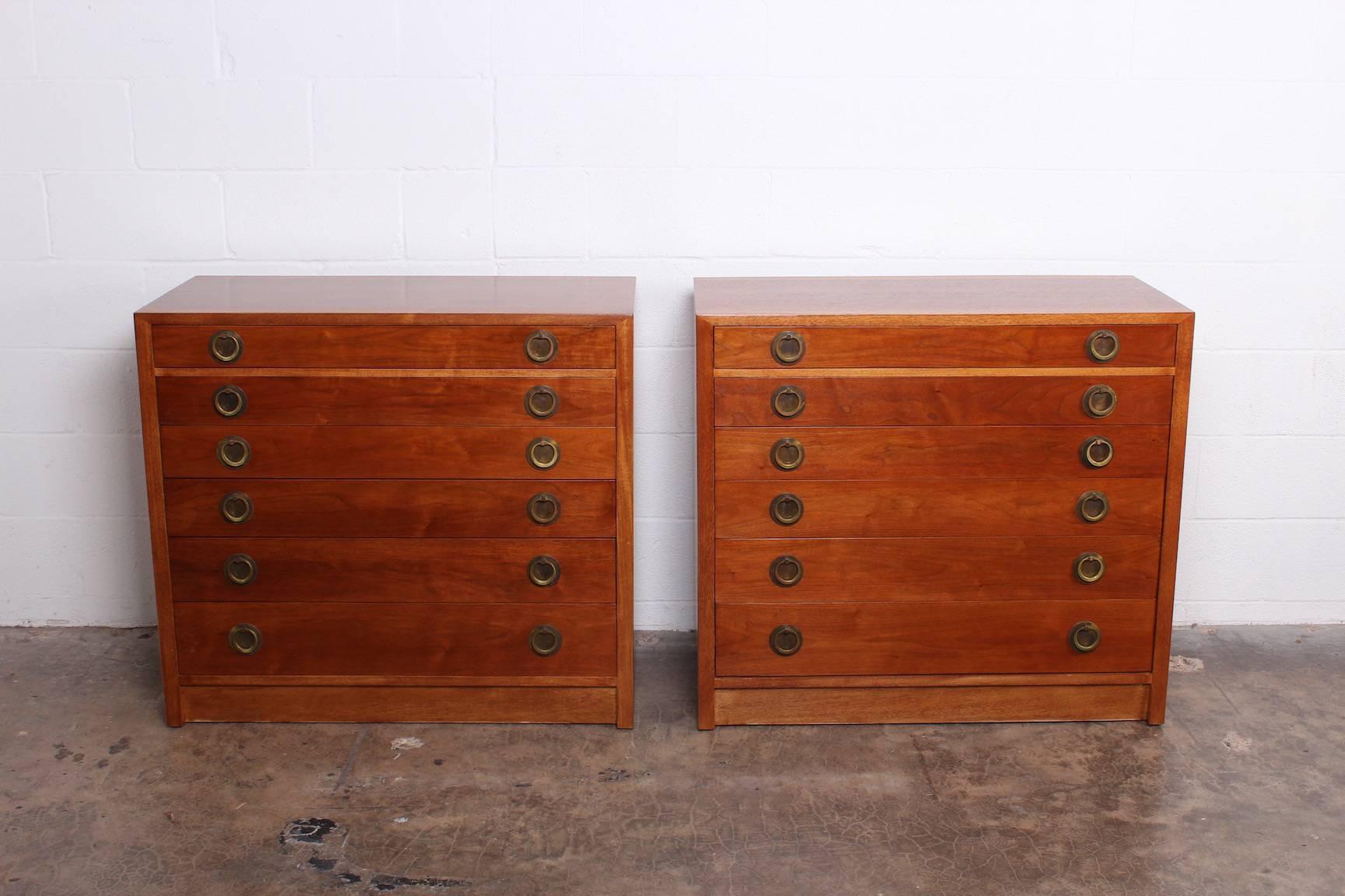 A pair of matching walnut and bleached mahogany chests with brass hardware. Designed by Edward Wormley for Dunbar.