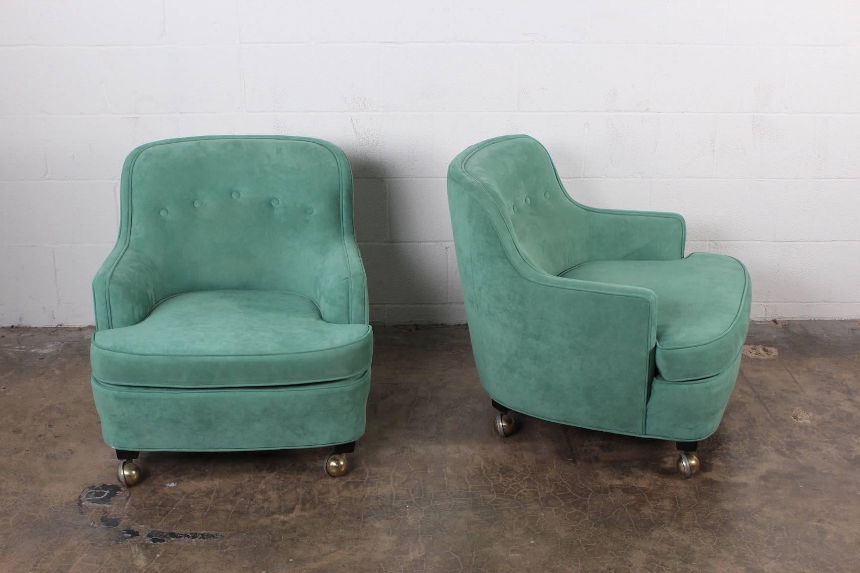 A pair of small-scale lounge chairs on casters. Designed by Edward Wormley for Dunbar.