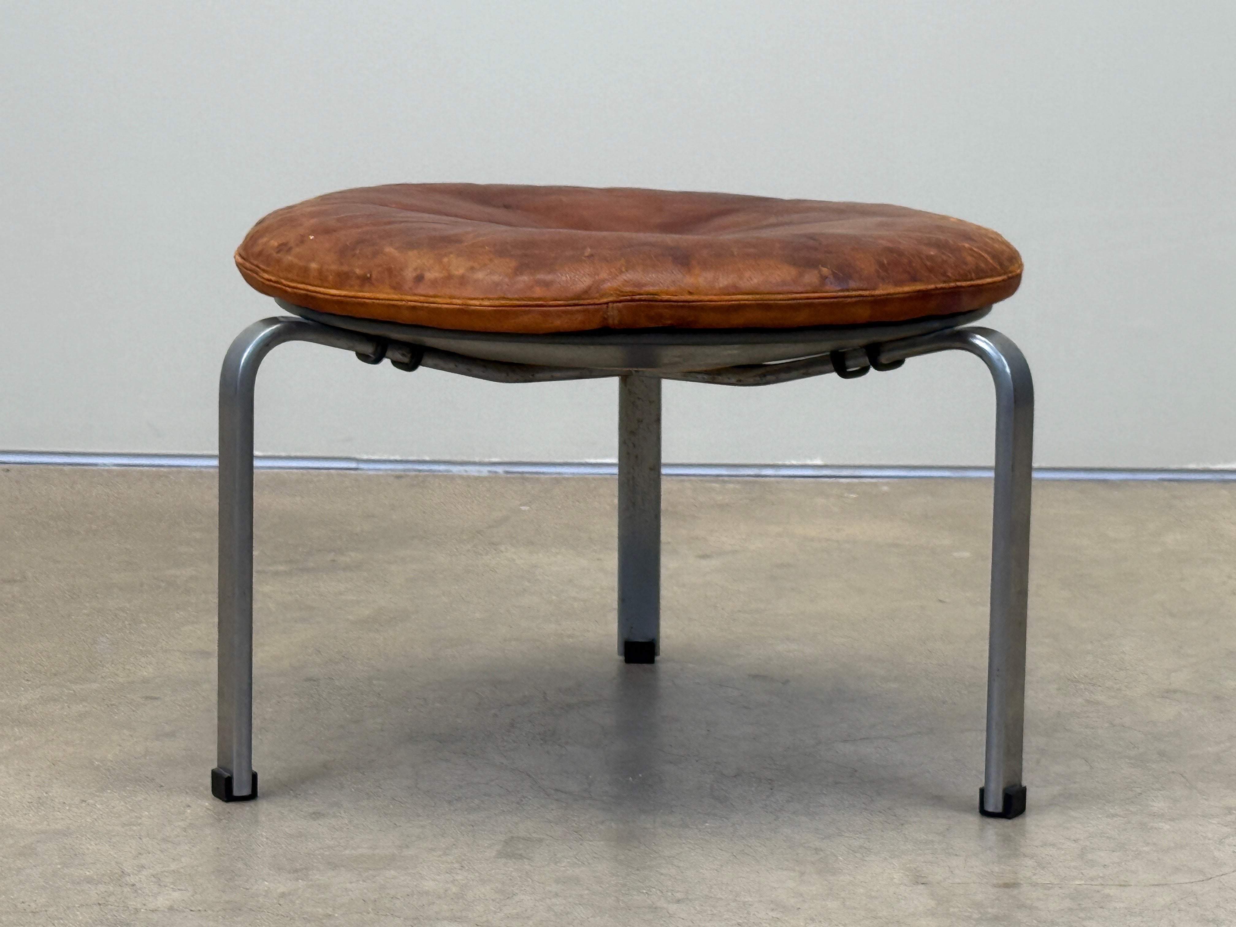 Poul Kjærholm PK 33 Hocker in schönem Originalzustand mit Patina auf Leder und Gestell. 