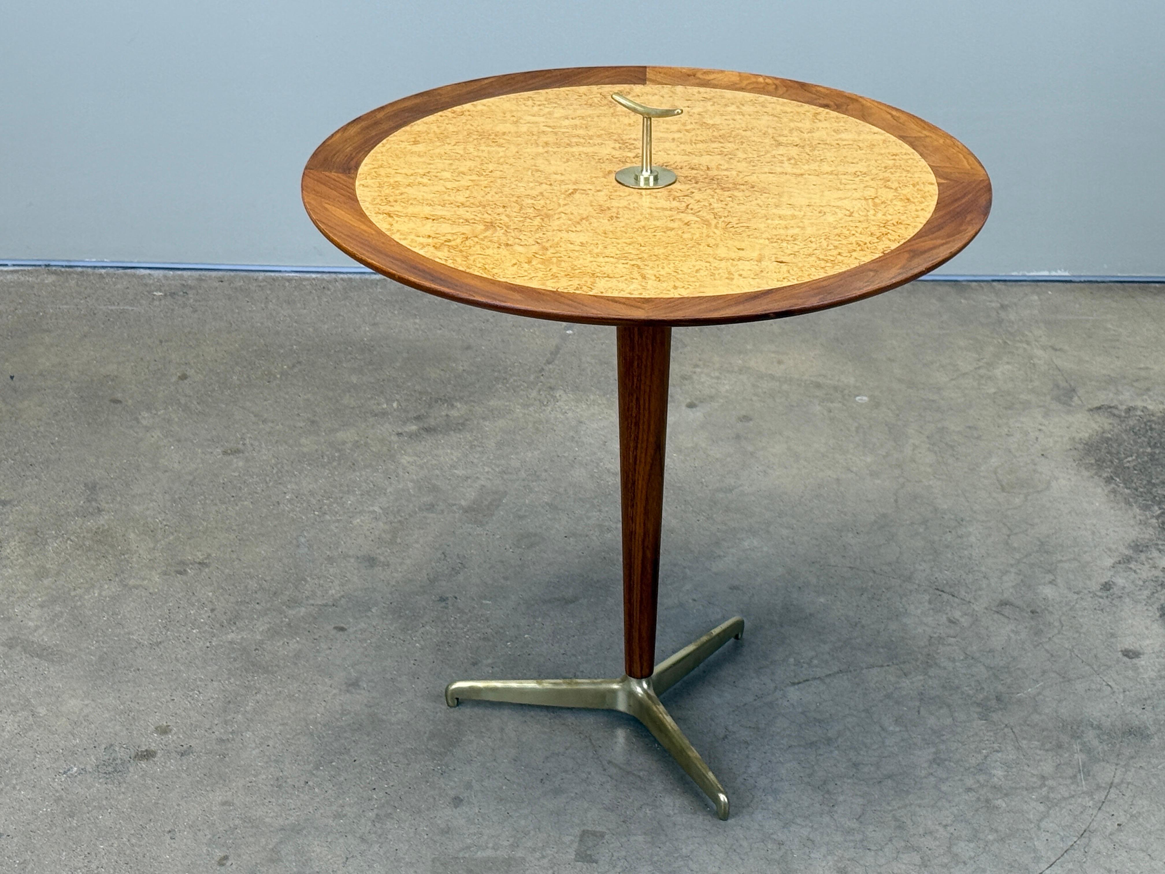 Edward Wormley for Dunbar Table à goûter avec pieds tripodes et fleuron en laiton, plateau en orme de Carpiti avec bord en noyer et montant central. Label numéro 4856, étiquette verte précoce de Dunbar. 
