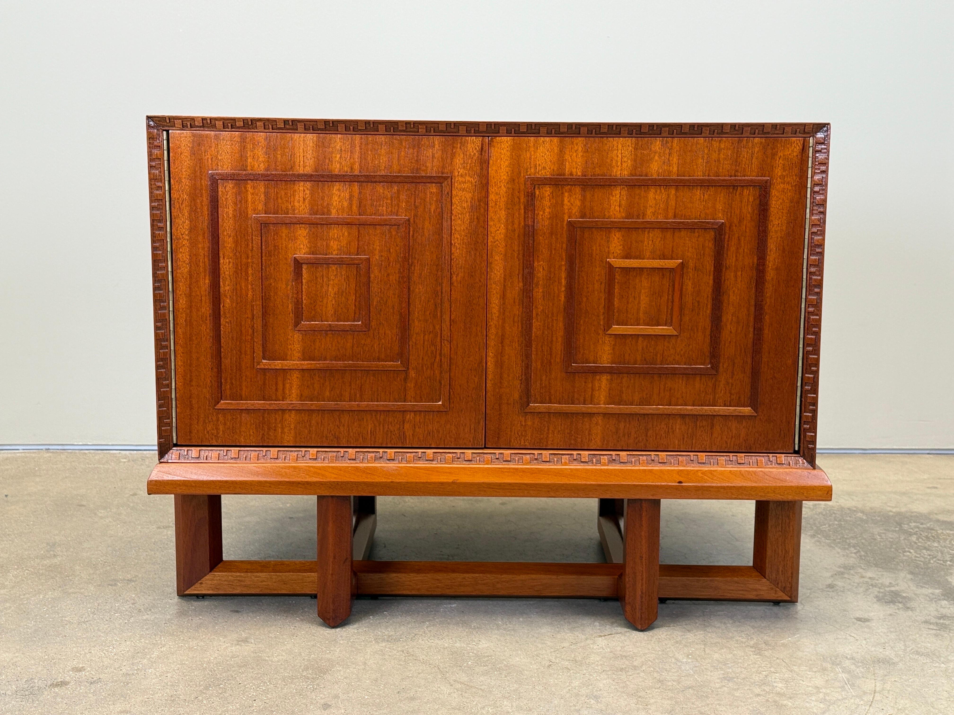 A rare cabinet / nightstand designed by Frank Lloyd Wright for Henredon. Cabinet with concentric squares door detail and greek key edging sits on top of a sculpted base. 