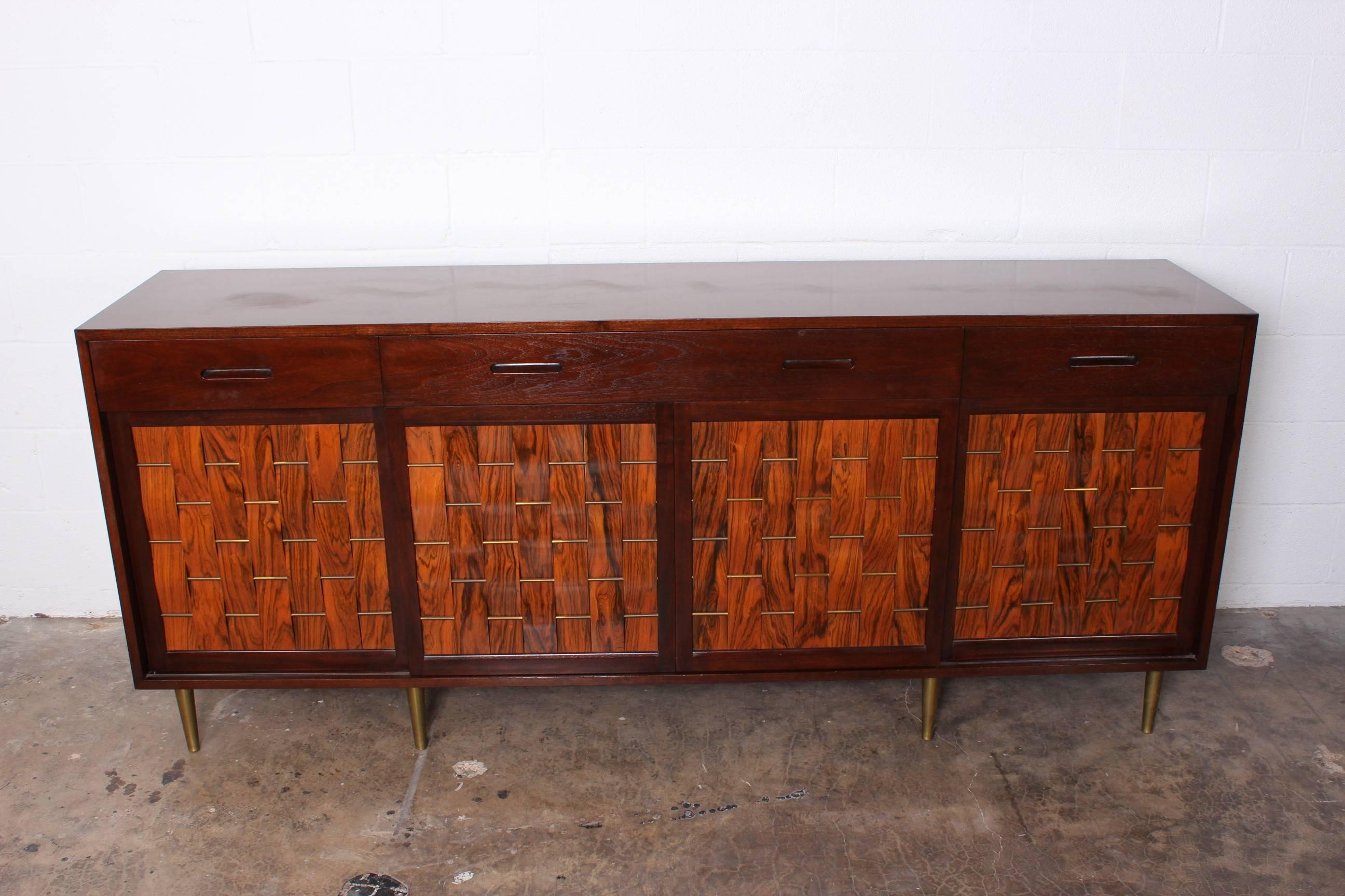 An exceptional design by Edward Wormley for Dunbar. Mahogany with woven rosewood front and brass legs.