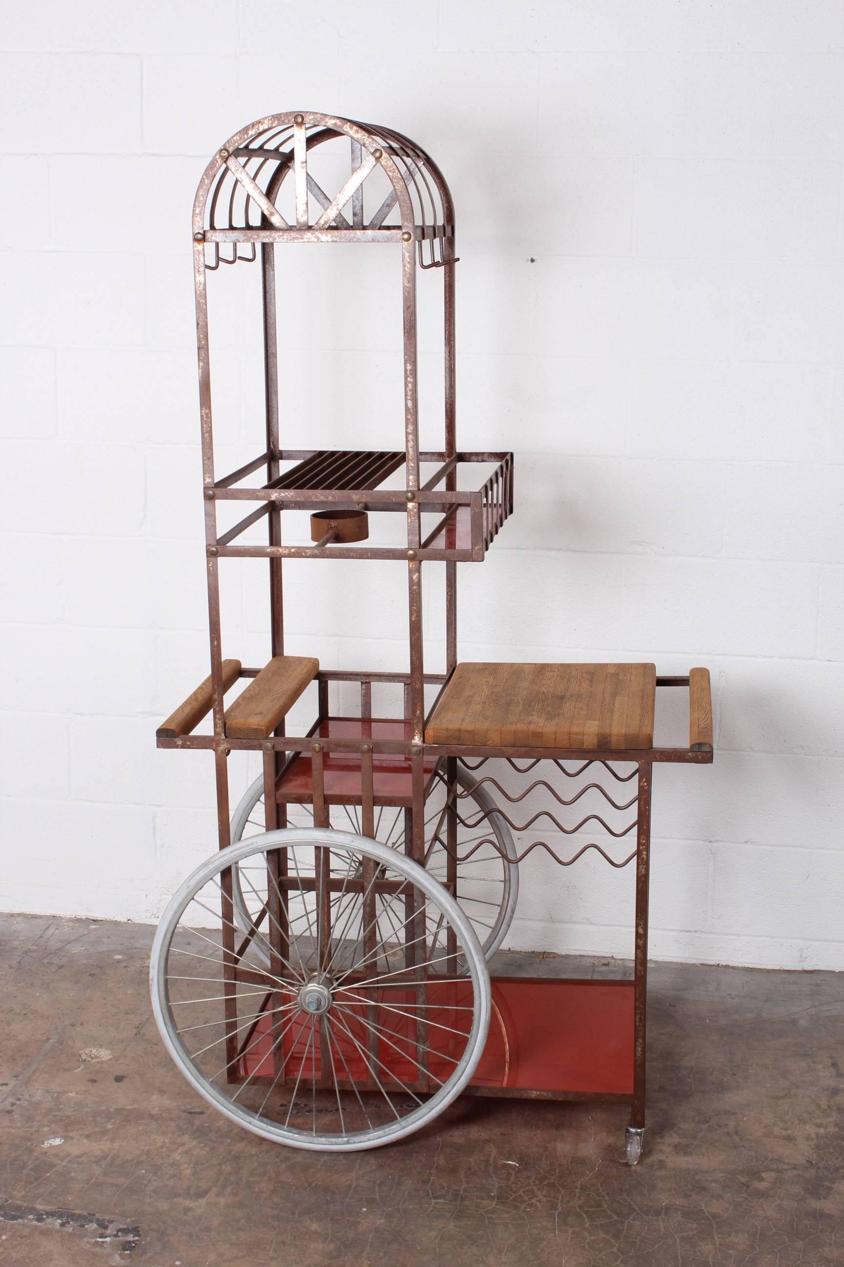 A large bar cart with bicycle wheels and patinated metal frame. Attributed to Bill Sanders.