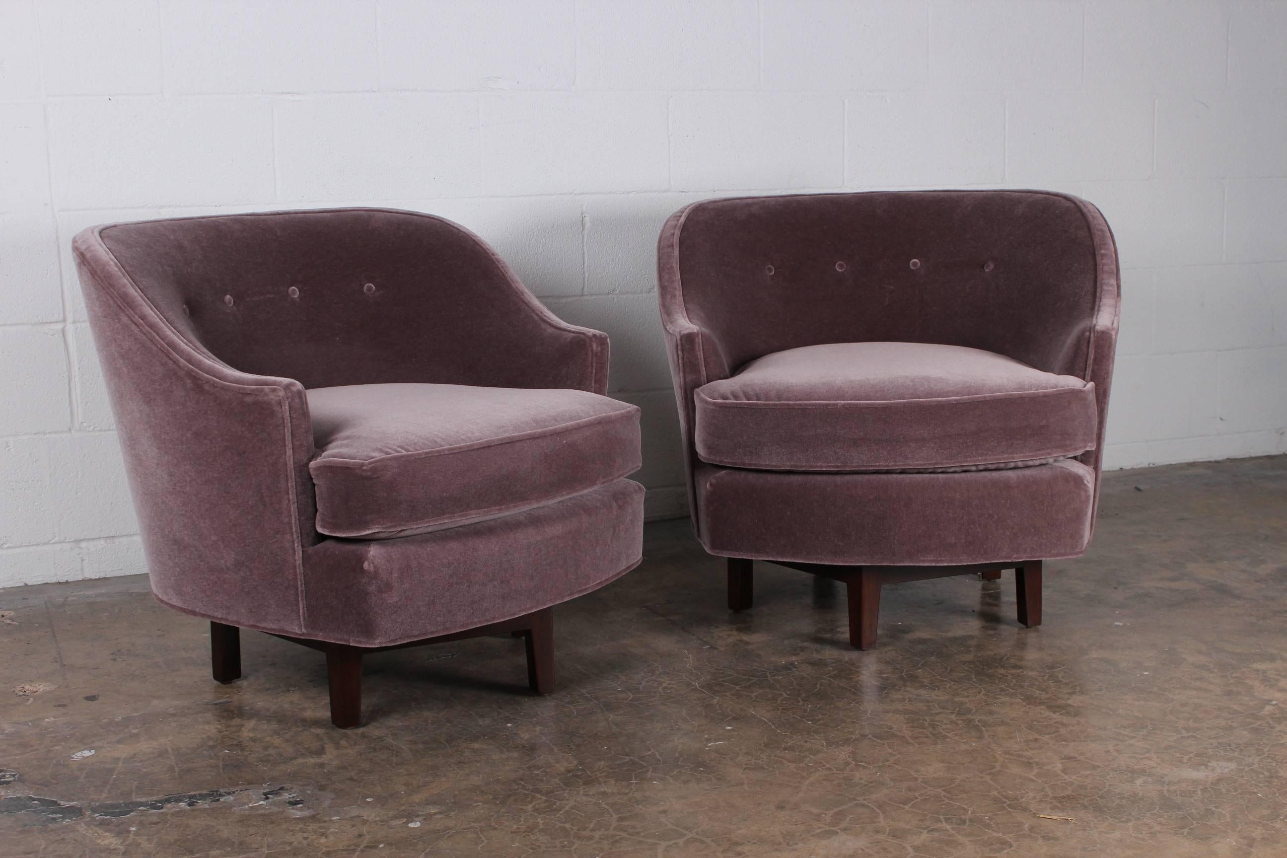 An elegant pair of swivel chairs on sculpted mahogany bases. Newly upholstered in mohair. Designed by Edward Wormley for Dunbar.