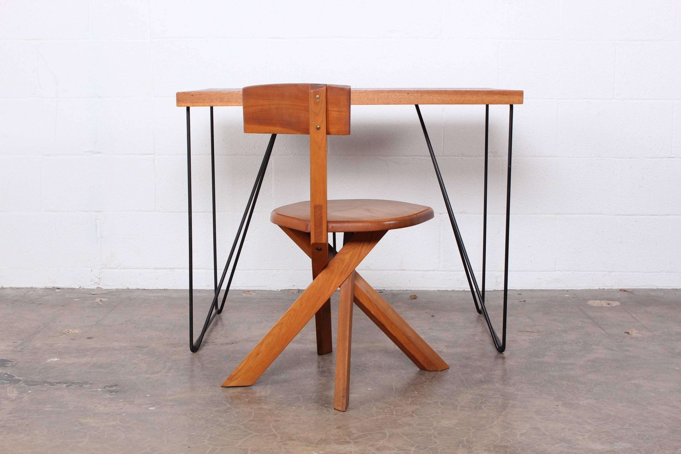 A simple form with wooden top and iron legs. Designed by Luther Conover. 