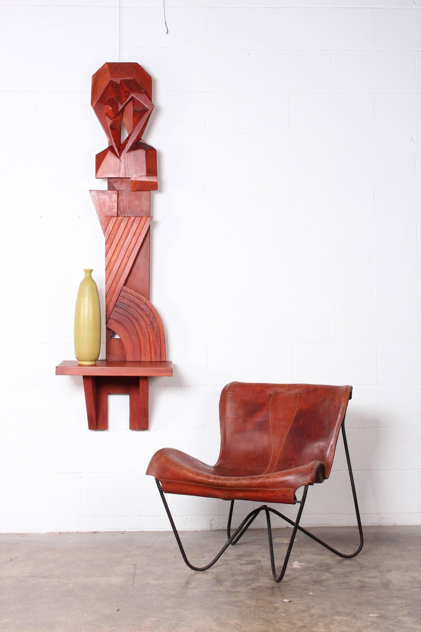A carved wooden wall mount sculpture with shelf. Crafted by artist Victor McKechnie in 1988 and titled 