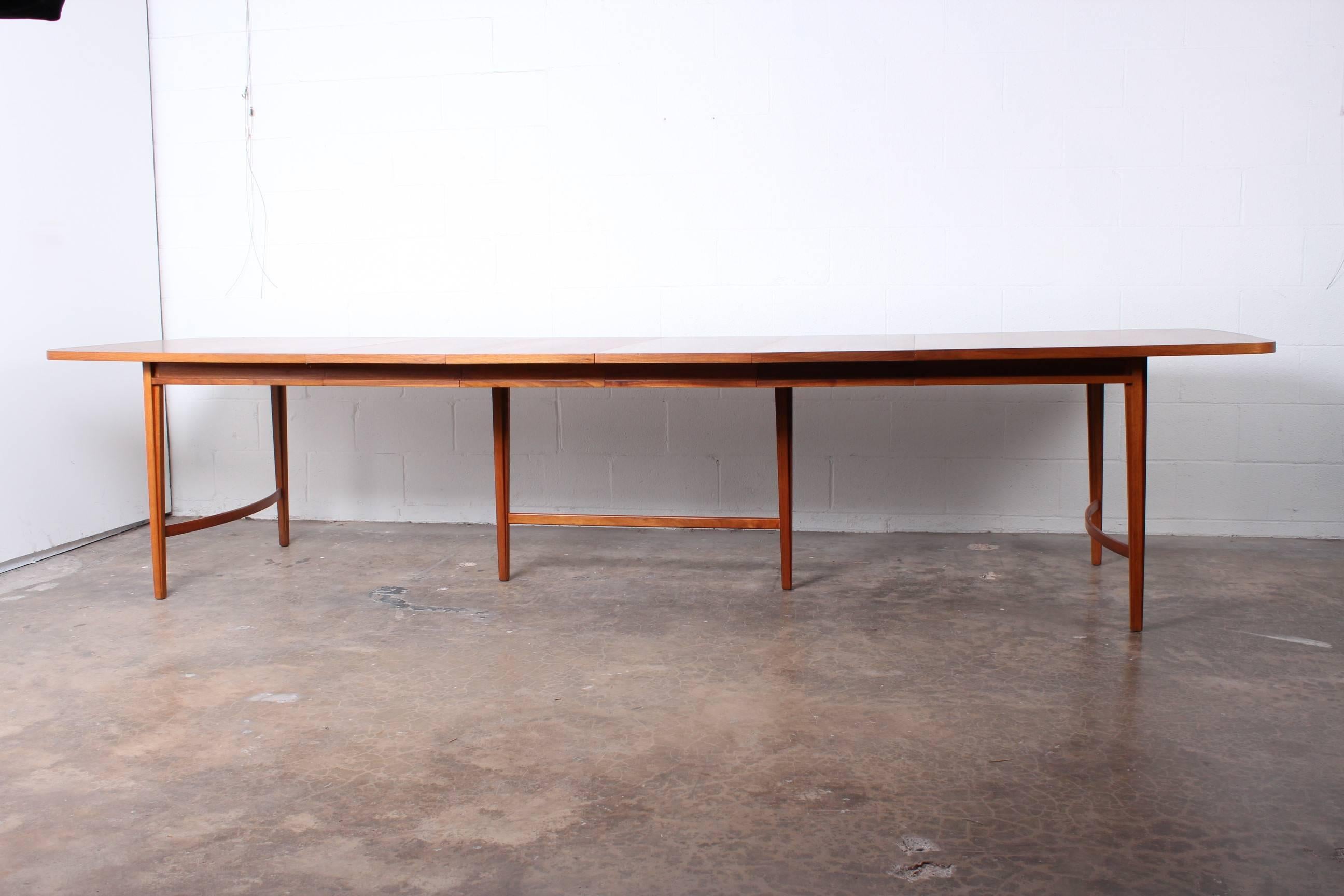 A large and uncommon walnut dining table designed by Paul McCobb. Table measures 72