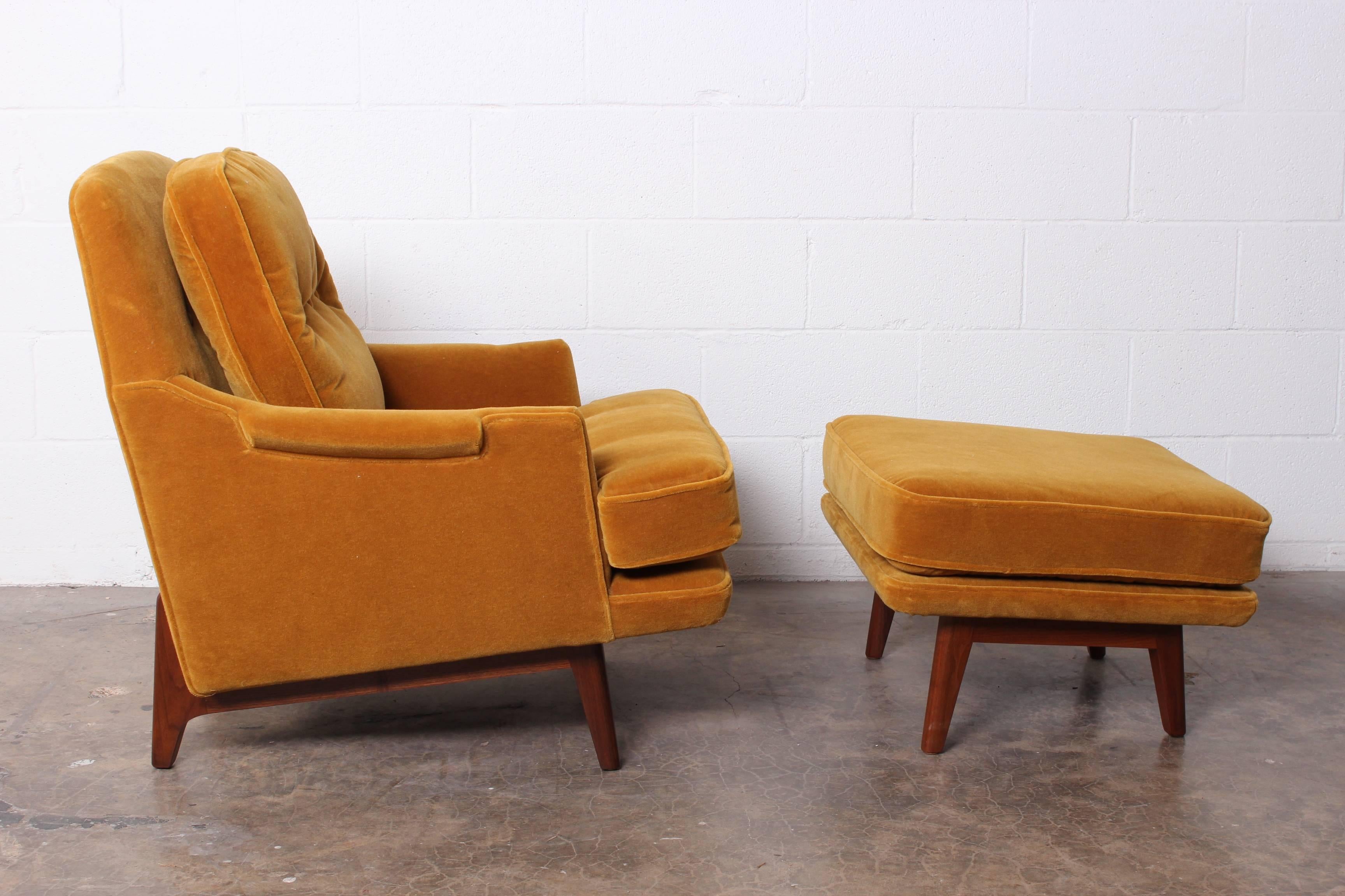 A Dunbar lounge chair and ottoman with mahogany base and mohair upholstery.