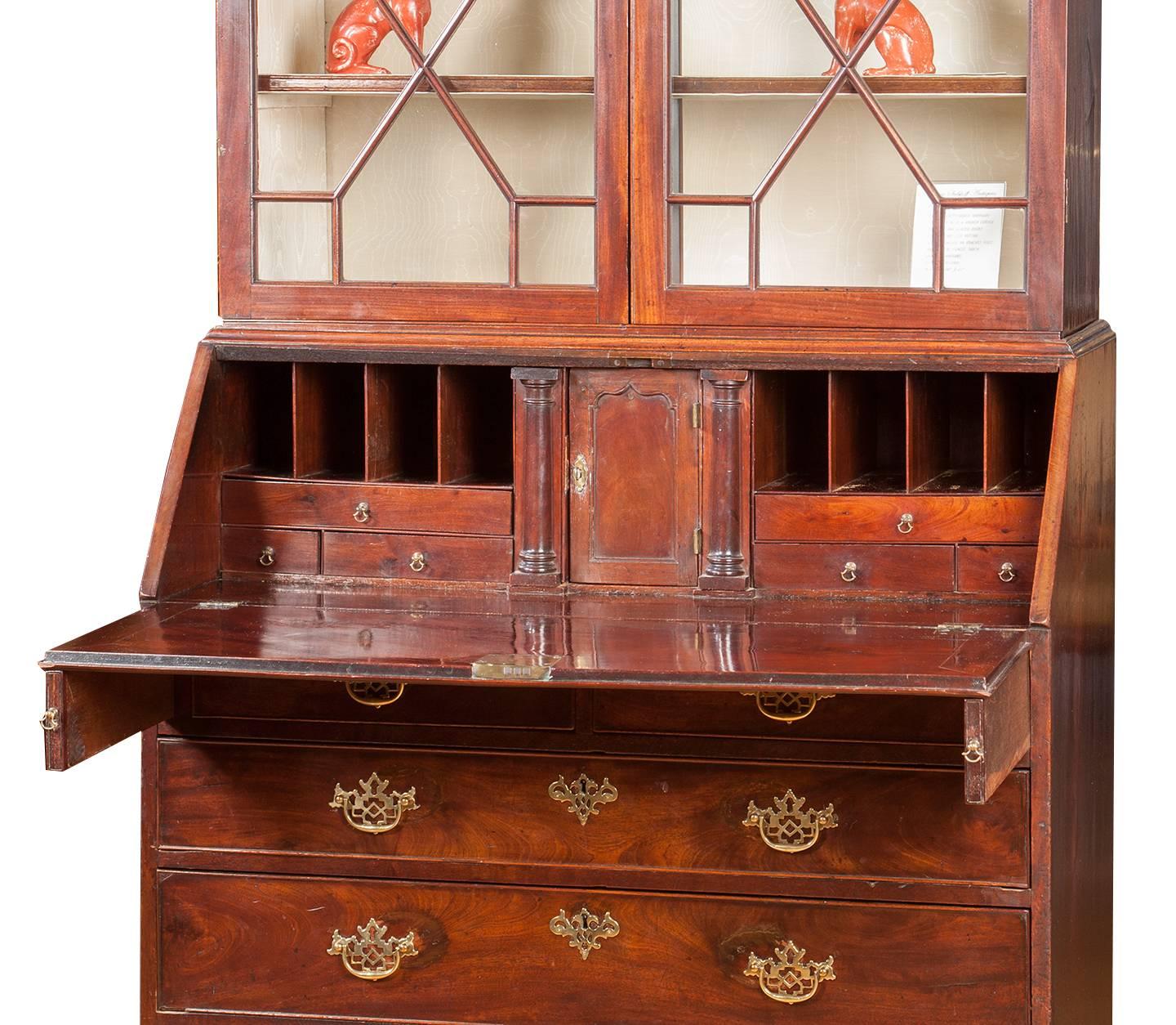 Chippendale secretary, with a carved broken, pediment top with glazed doors,
the bottom with a slant front, the interior with small drawers and document column shaped drawers, below two small and three larger graduated drawers
made from the finest