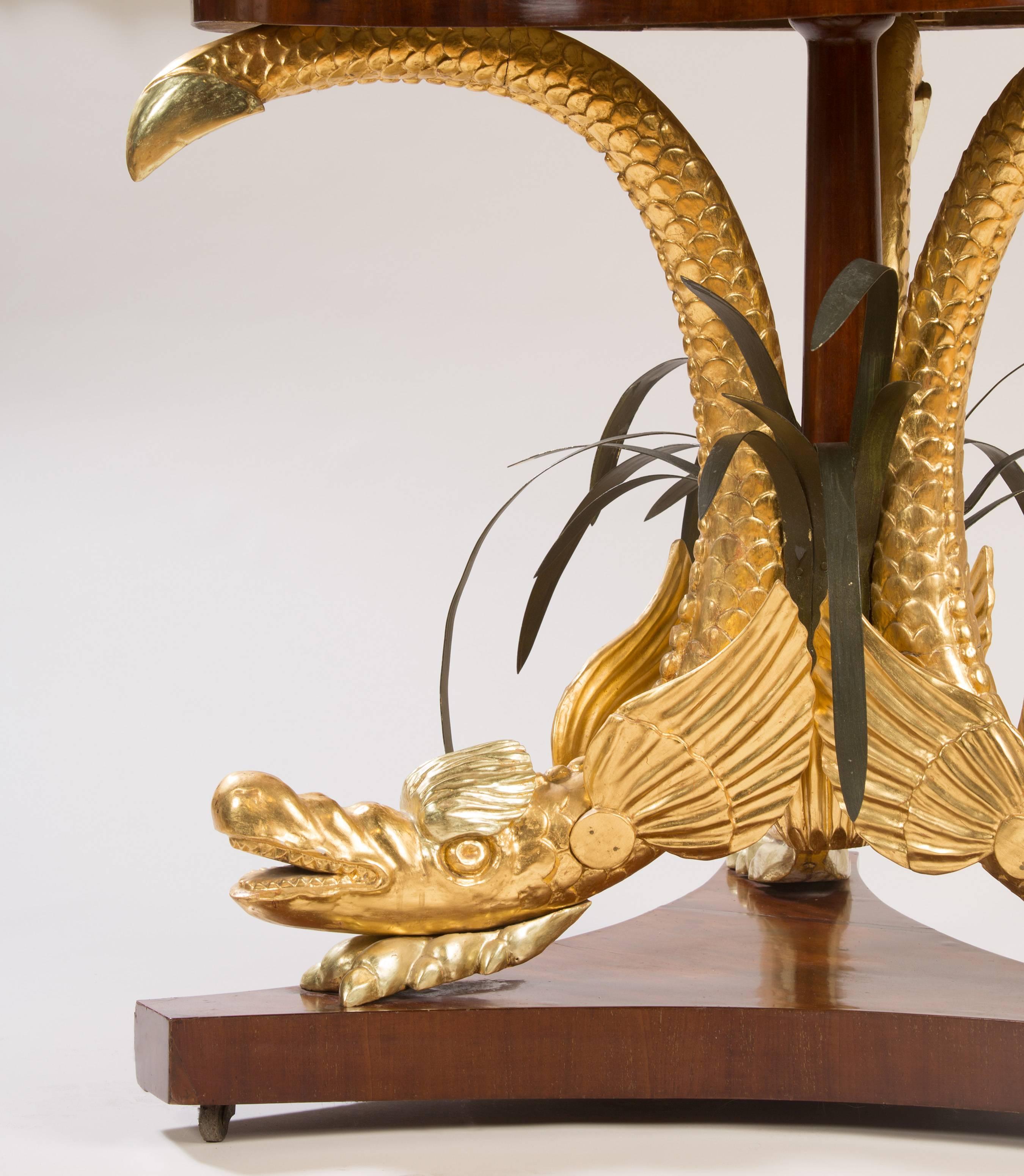 A quite whimsical mahogany gilt and tole marble-top center table
with the original dished marble, mythological gilded sea serpents with painted tole leaves.