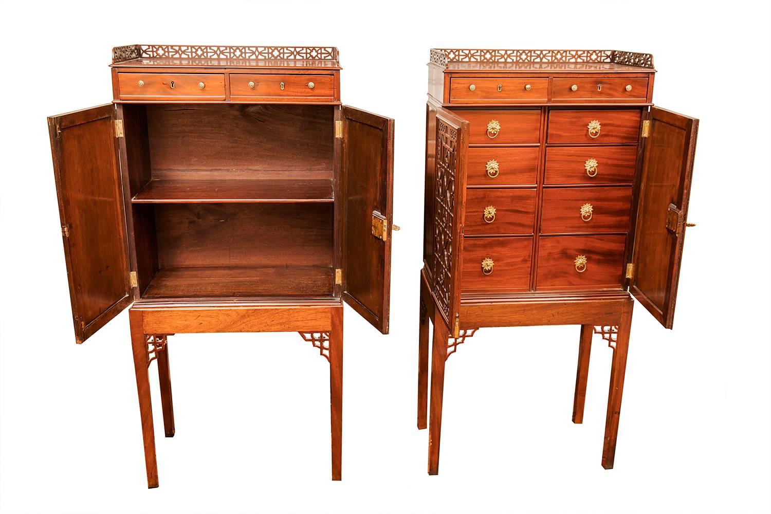 A pair of pierced gallery two-door relief carved small cabinets, one with shelves for books
the other with small drawers supported on stands with pierced brackets and tapered legs.