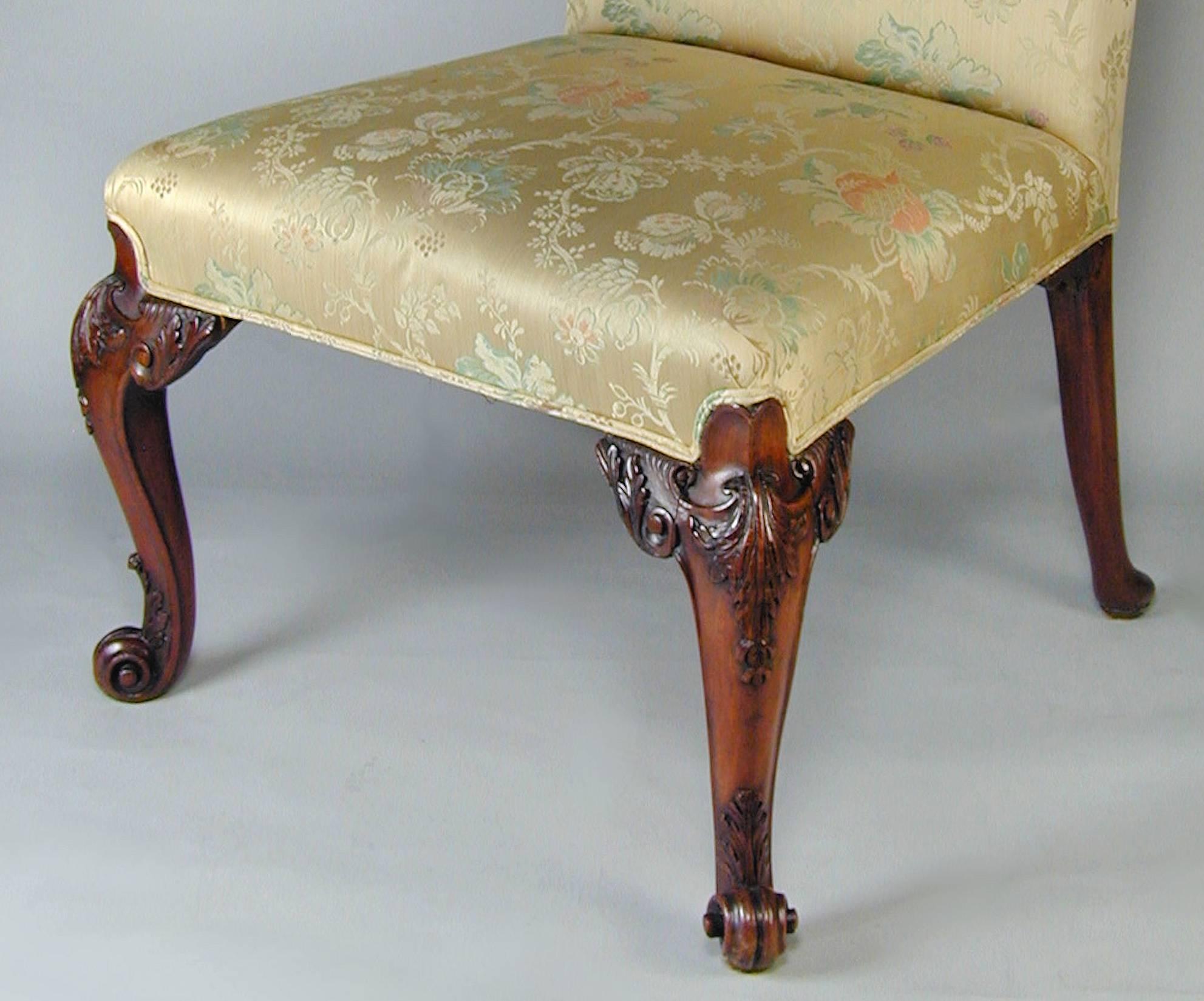 An exceptional pair of English mahogany carved side chairs on shaped cabriole legs ending in scroll feet, circa 1760. These pieces are currently located at our second location in London. We can ship these internationally. 