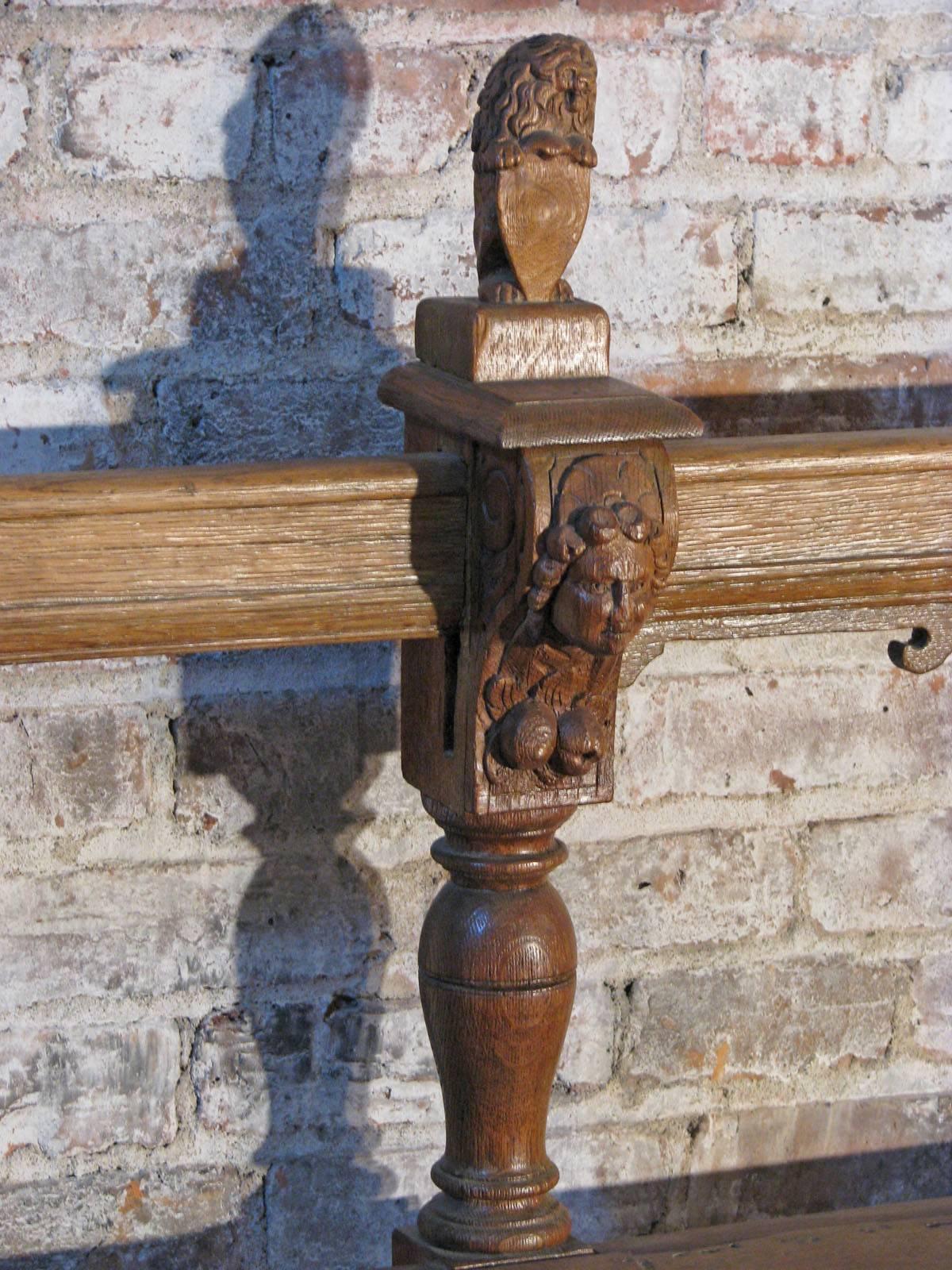 Rare, unusual and decorative bench, decorated with numerous carved human and lion heads and lion finials. The bulbous turned legs and backrest connected by flat, reeded stretchers.
