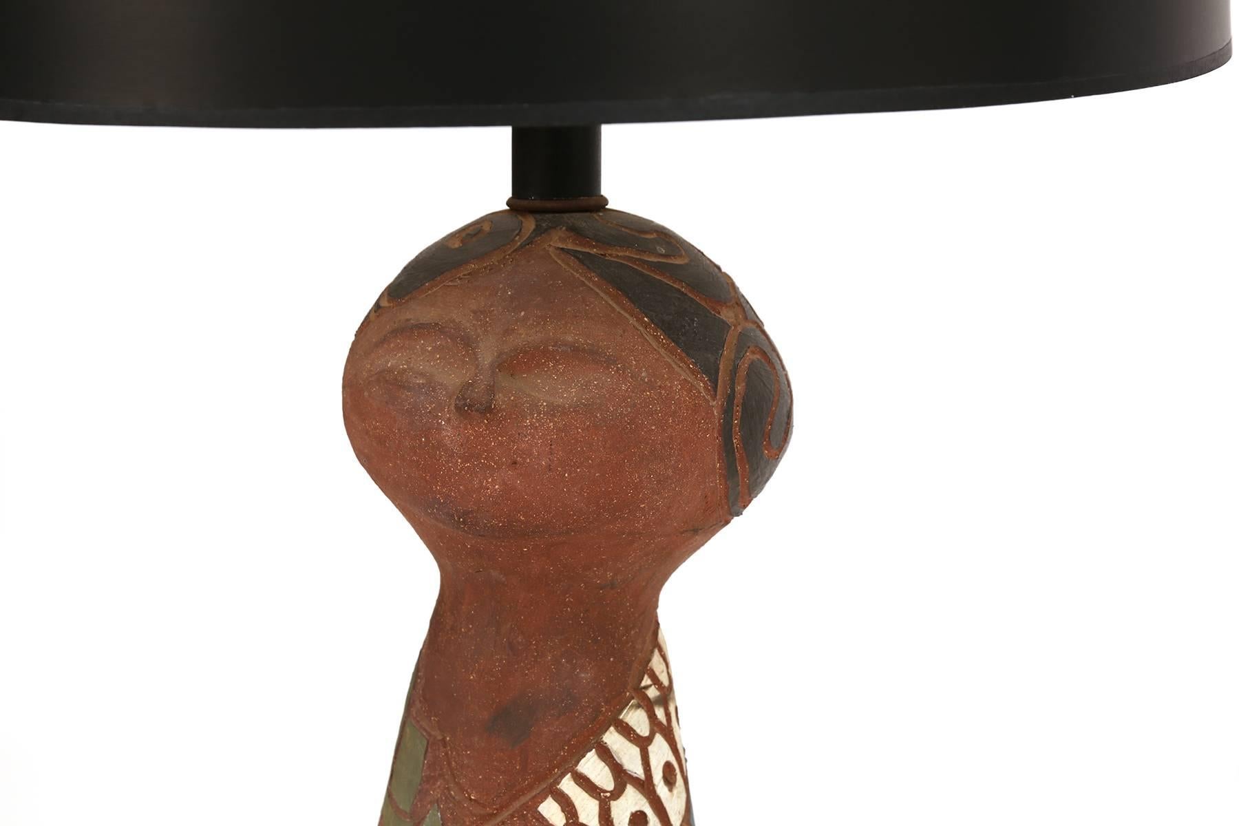 California studio large-scale terra cotta lamp, circa early 1960s. This example reminiscent of the works of Raul Coronel and Brent Bennett is hand-carved and glazed and sits atop a walnut base. Priced without the shade. Red can procure a shade for