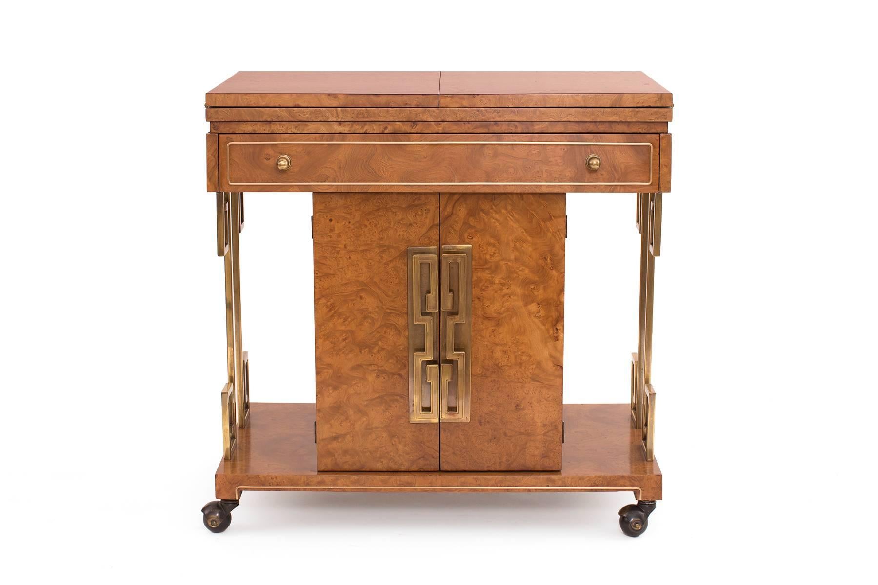 Stunning brass and burl barcart by Mastercraft, circa early 1960s. This example has patinated brass greek key door pulls and accents. The fabulous burl wood case has been newly finished. Top is expandable.