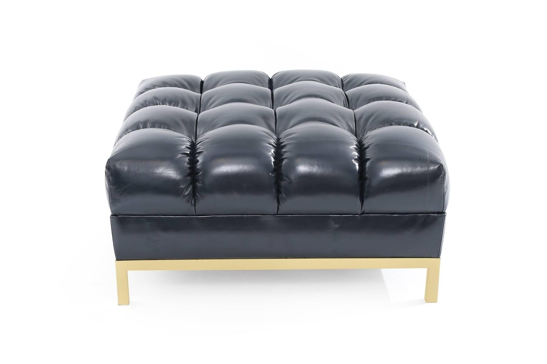Deep tuft navy leather and brass ottoman or bench circa late 1950s.
This fabulous example has a satin finished brass base and has been newly upholstered in a supple and chic navy leather.