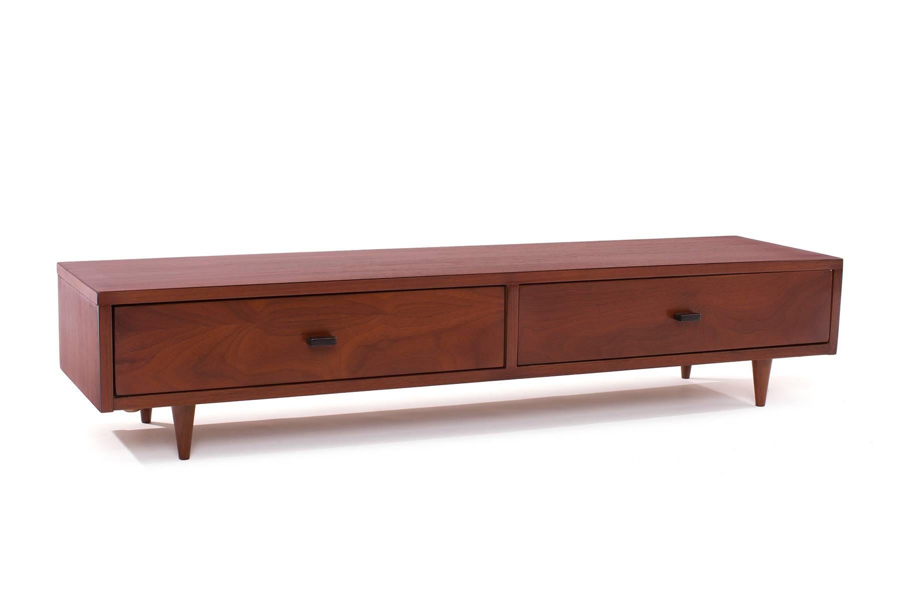 Walnut and metal jewelry chest, circa early 1950s. This example has beautifully grained walnut, two drawers with metal drawer pulls and tapered walnut legs.