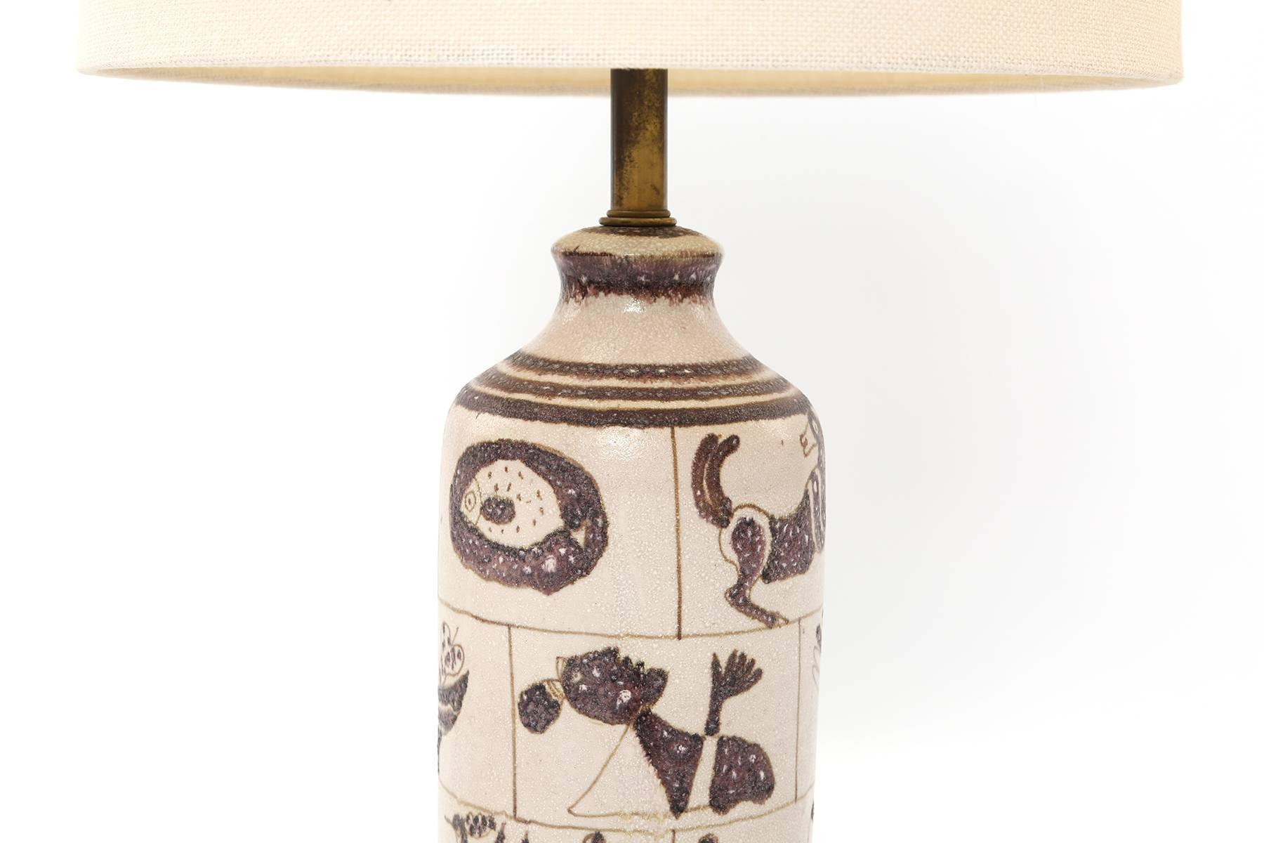 Guido Gambone for Marbro ceramic table lamp, circa early 1950s. This fabulous example has a textural glaze with figural and animal motifs. Sits atop a newly finished solid walnut base. Newly wired. Price includes shade pictured.