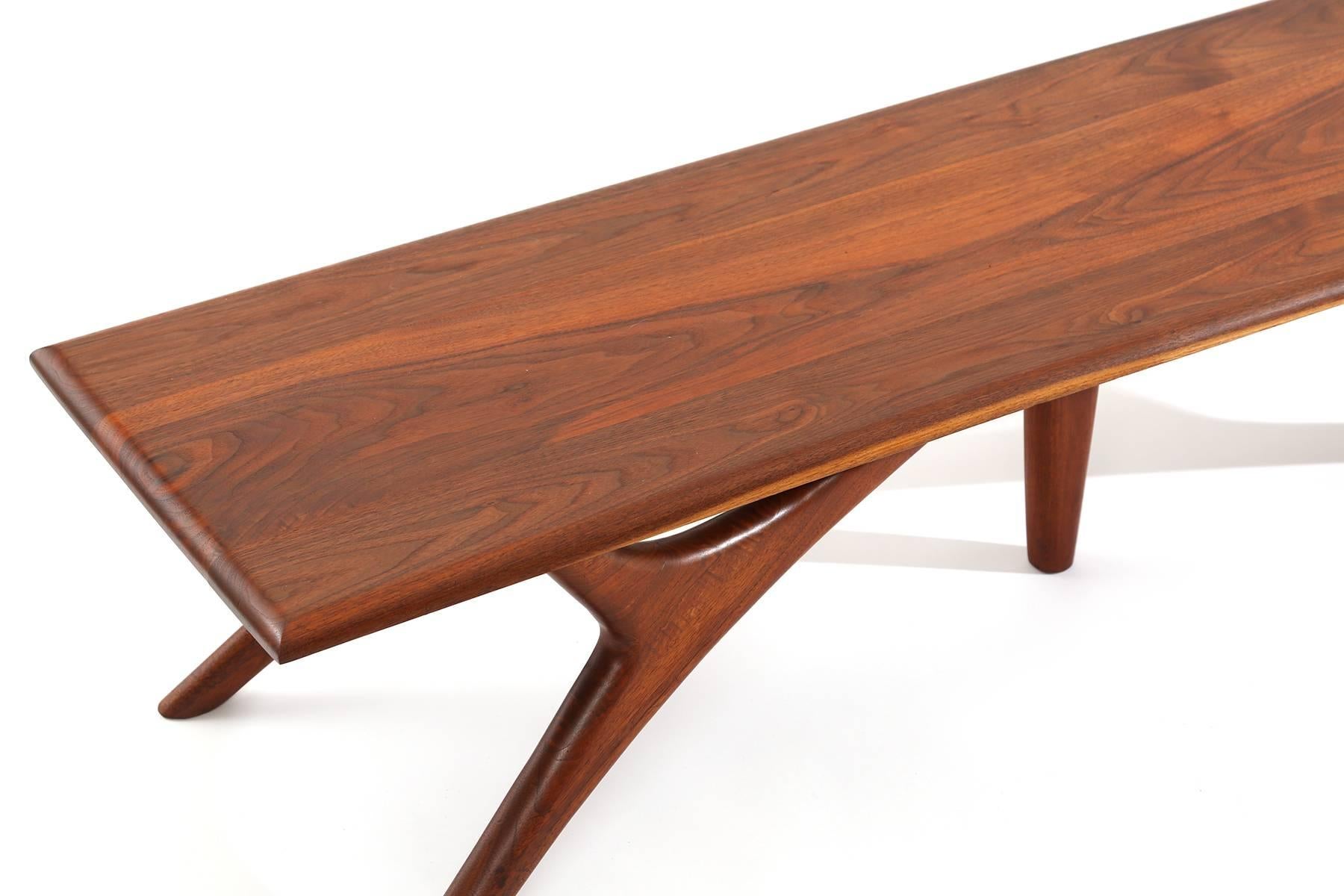 Sculptural solid walnut cocktail table circa early 1950s. This example has beautifully tapered and formed legs with lovely graining to the solid walnut top.