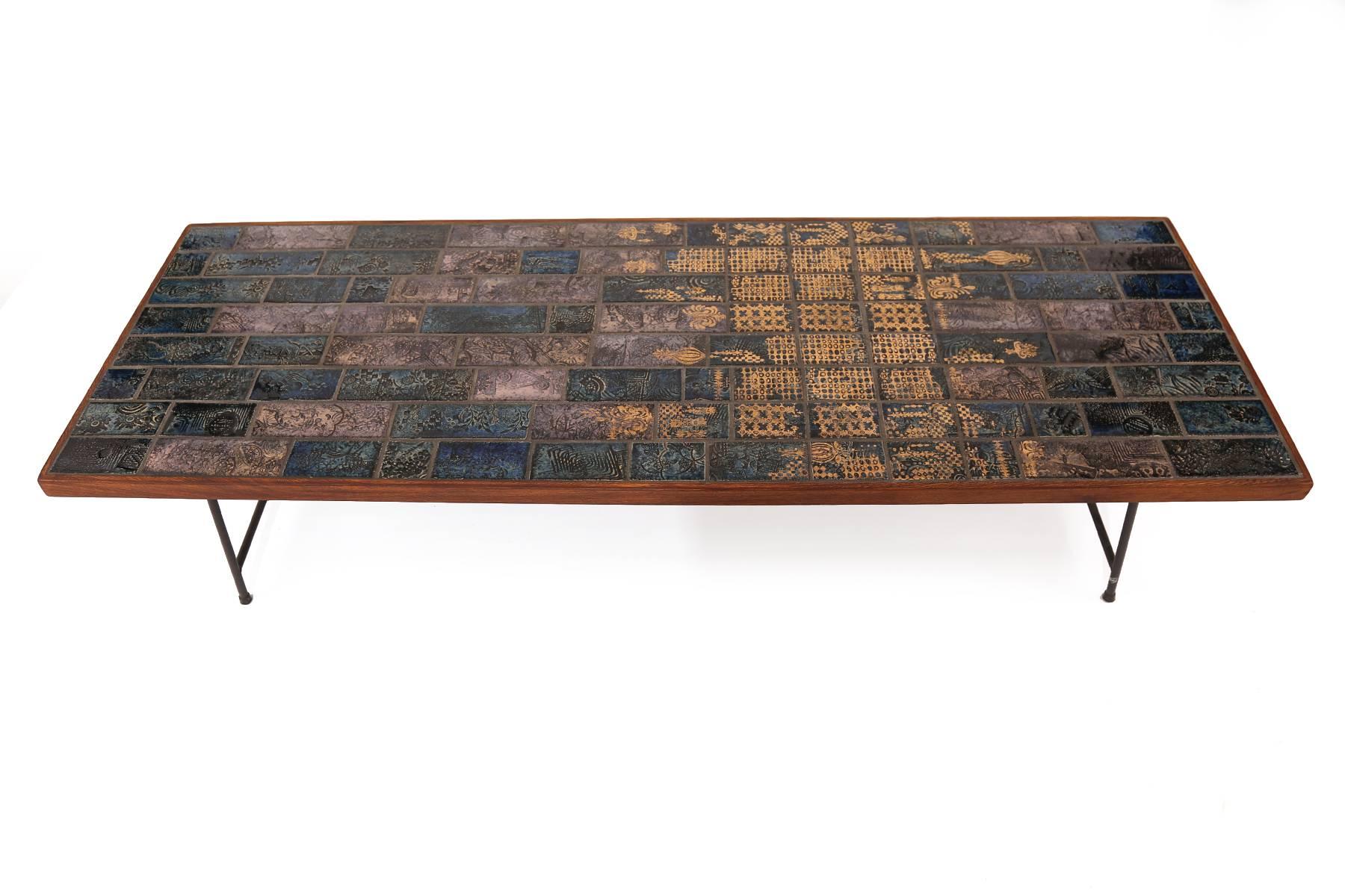 Bjorn Wiinblad tile mahogany and iron cocktail table, circa mid-1960s. This example has beautiful deeply hued inset ceramic tiles on the top with solid mahogany banding.
The base is patinated solid iron.