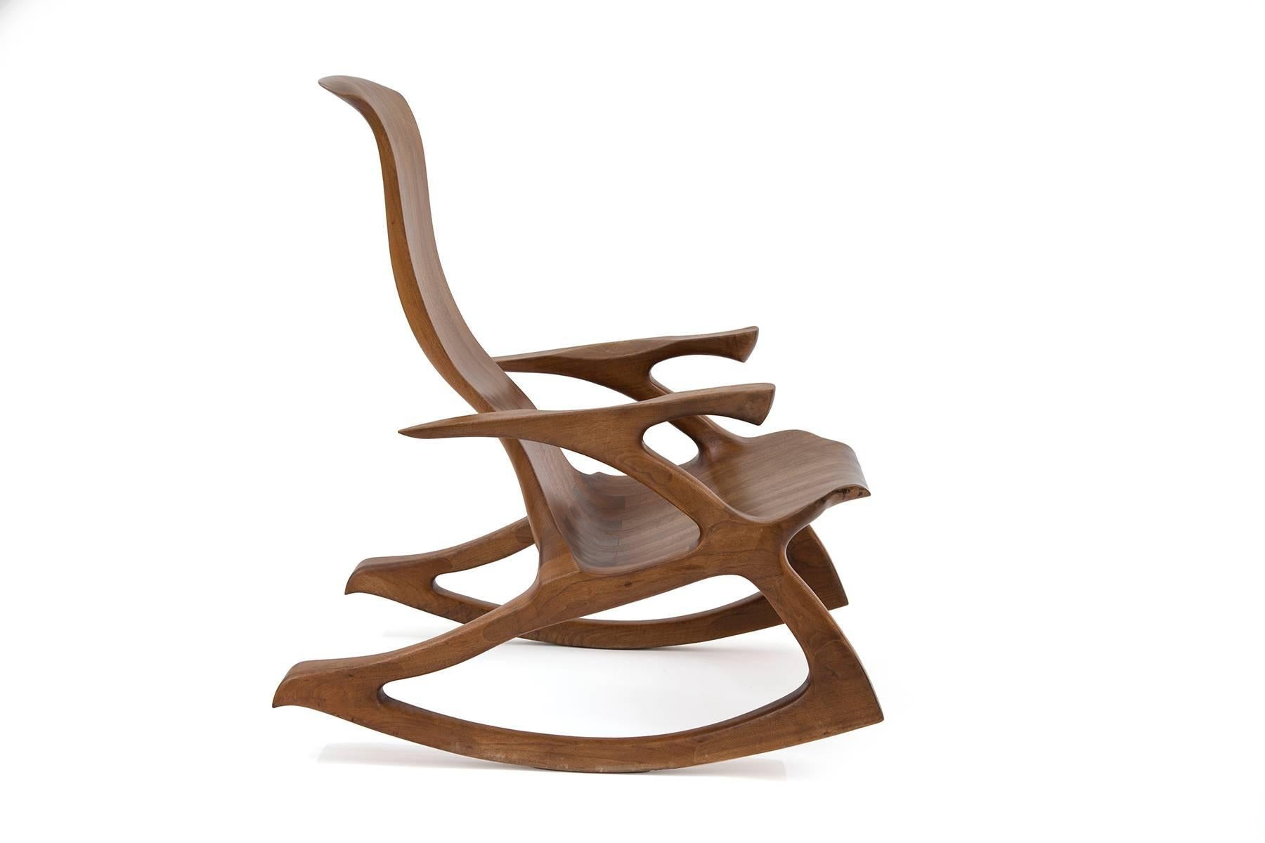 Solid walnut studio crafted rocking chair. This example has sculpted arms and frame with inset dove tailing and subtly curved back. Looks incredible from every angle.