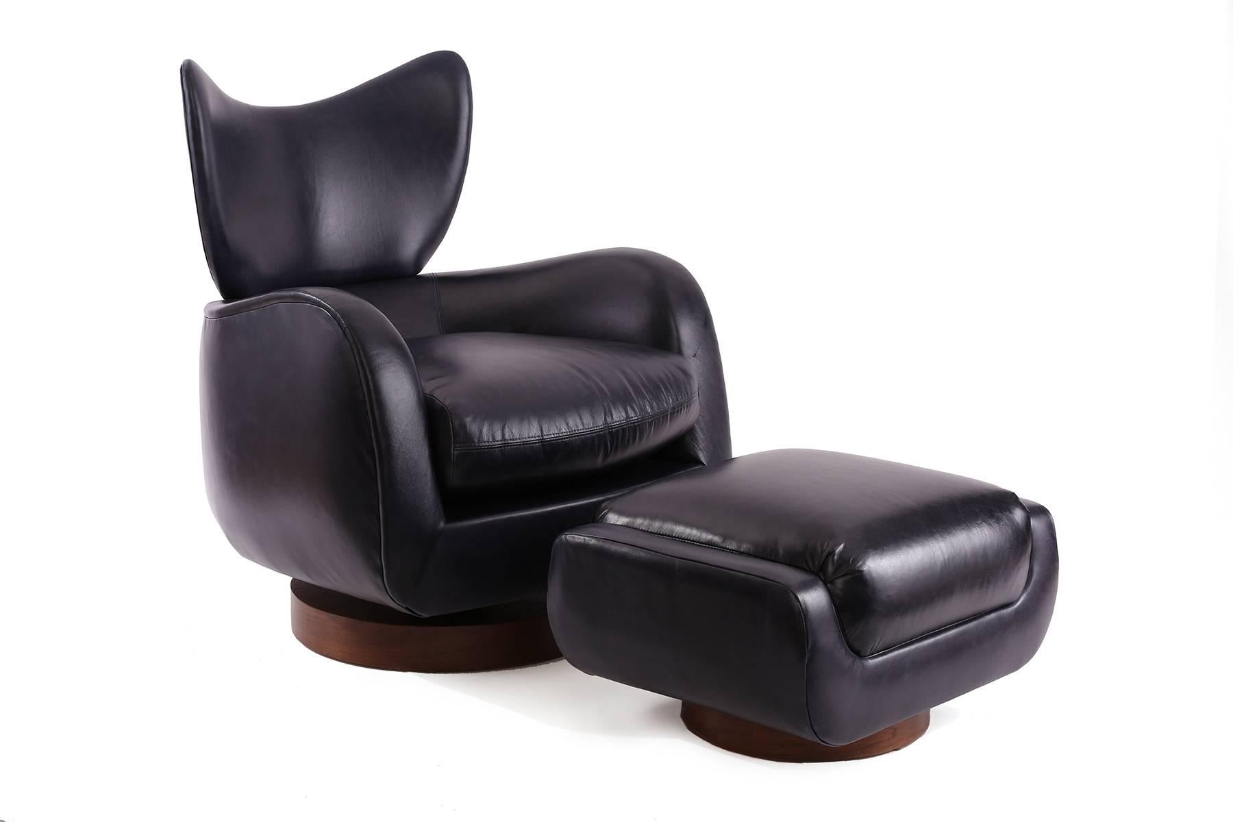 Pair of Vladimir Kagan for Directional swivel and reclining lounge chairs and ottoman, circa late 1970s. These sculptural examples have been newly upholstered in a patinated navy leather and sit atop circular spring loaded walnut bases.
Price is