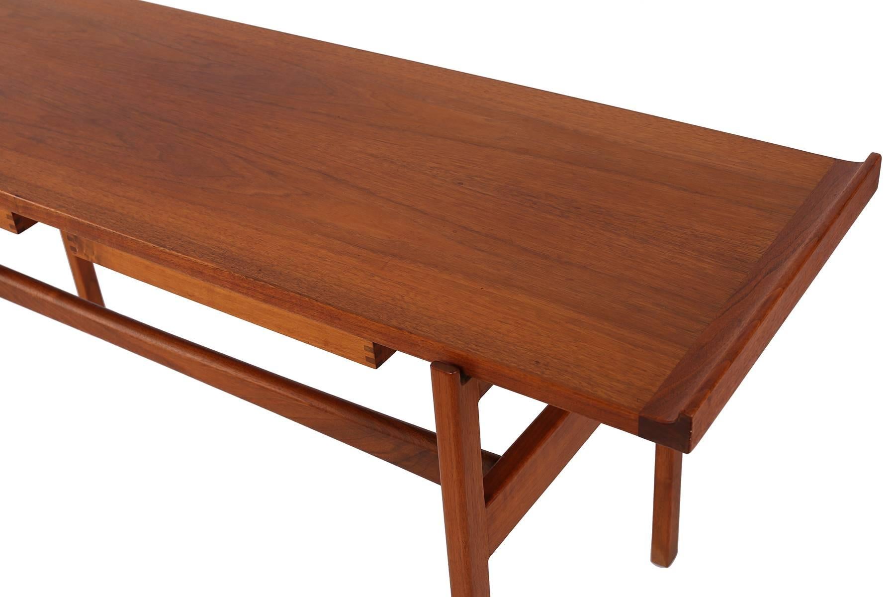 Early Jens Risom solid teak sofa or console table, circa early 1960s. This all original example has two drawers with exposed dove tailing and a floating inset top that rests inside the unusual solid teak legs. Finished on all sides.
