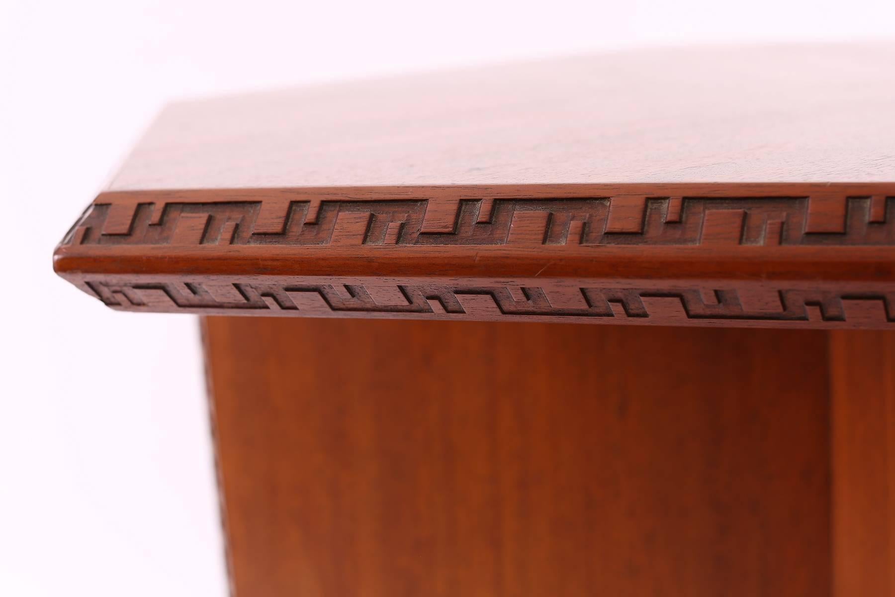 Frank Lloyd Wright for Henredon occasional table circa late 1950s. This all original example from the 'Taliesin' line has the iconic carving in the edging and is executed in beautifully grained striped African mahogany.