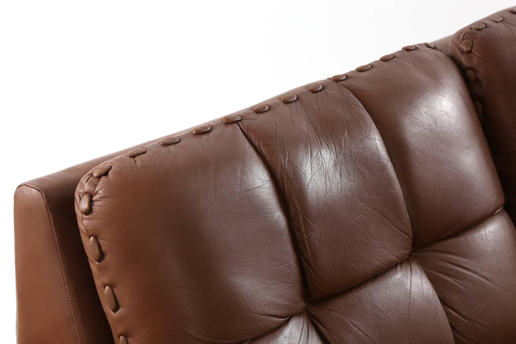 Hand-stitched patinated leather sofa by De sede, circa late 1970s. This all original example has baseball stitching on the arms and cushions and is upholstered in a supple perfectly broken in milk chocolate leather. Very comfortable.